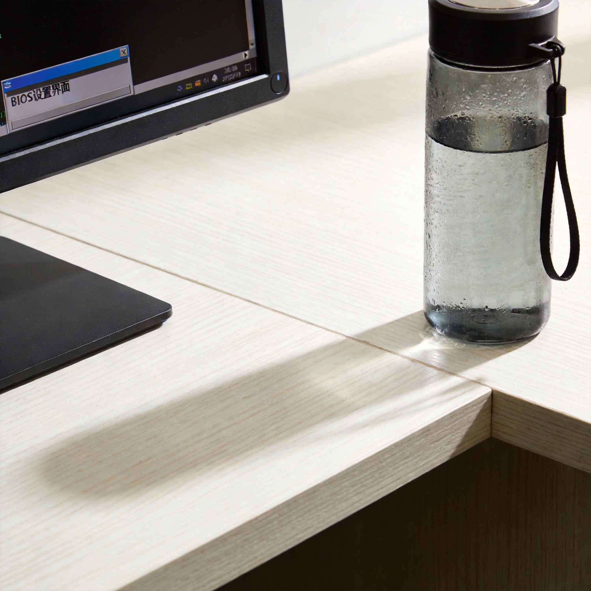 书桌上的电脑,屏幕显示BIOS设置界面,桌角放着水杯,自然光 书桌上的电脑,屏幕显示BIOS设置界面,桌角放着水杯,自然光