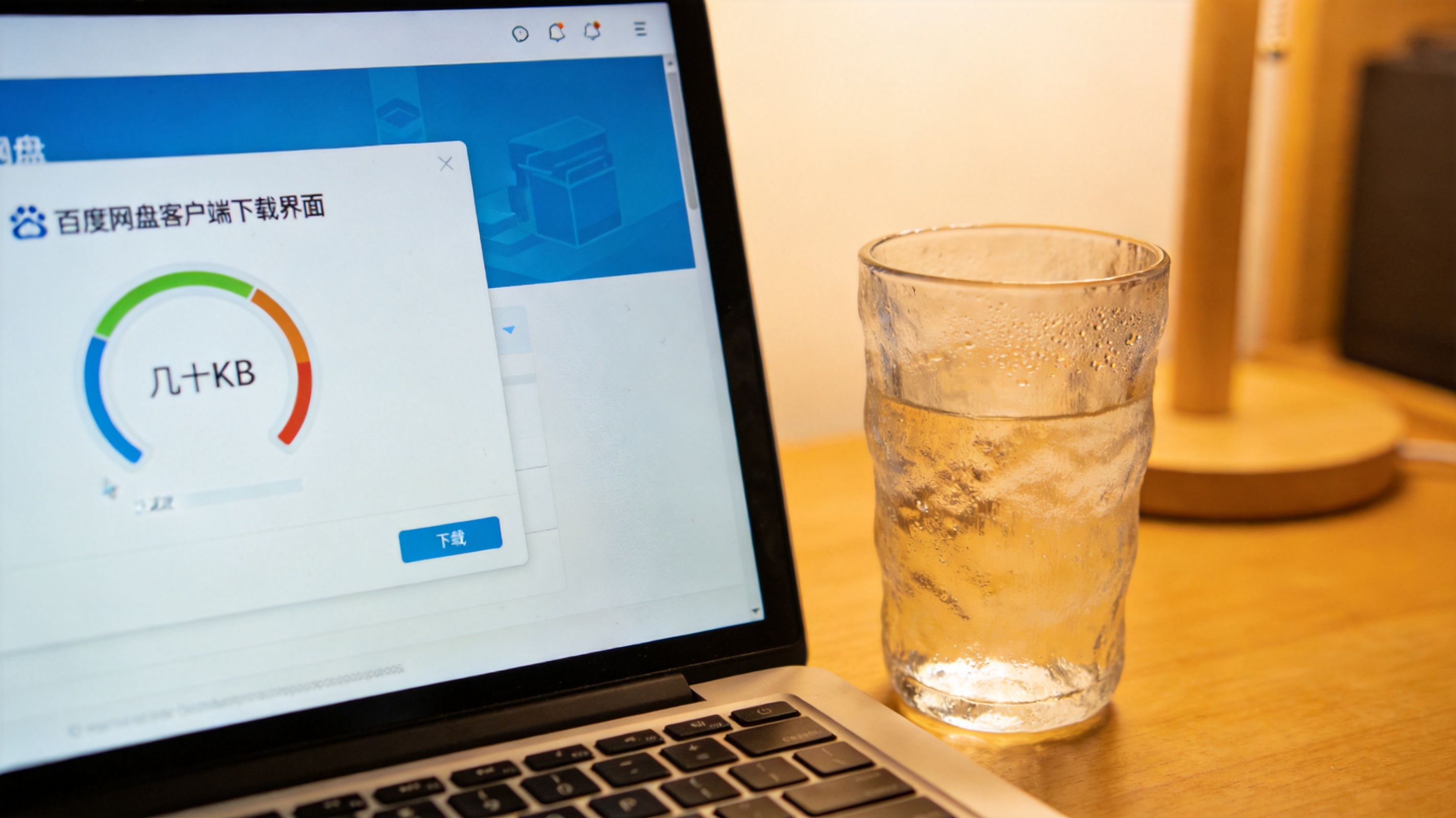 电脑桌面，屏幕显示百度网盘客户端下载界面，下载速度显示几十KB，旁边放着半杯温水，室内自然光