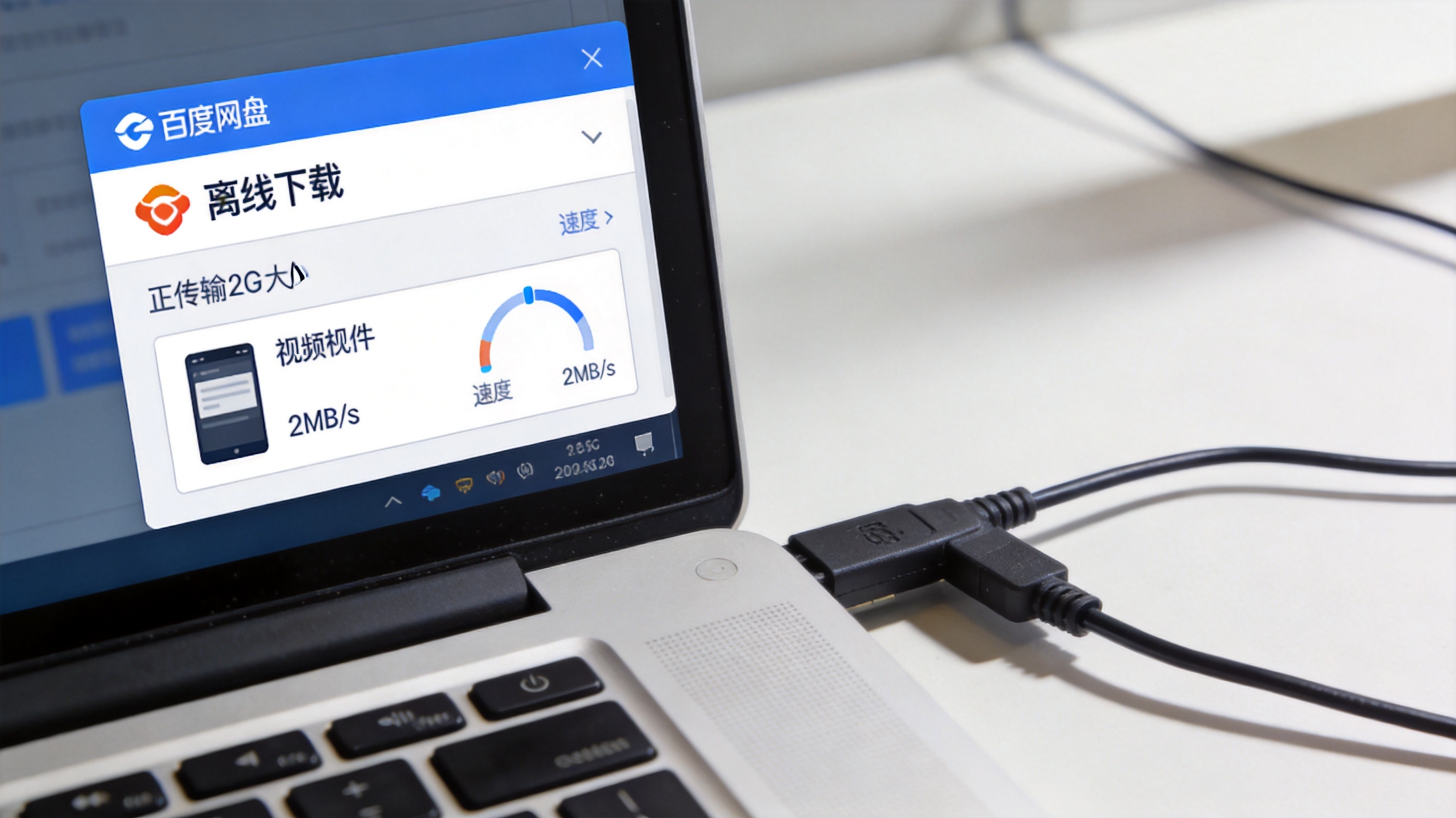 电脑桌面，屏幕显示百度网盘客户端的离线下载界面，正在传输2G大小的视频文件，速度显示2MB/s，旁边放着连接电脑的有线网线
