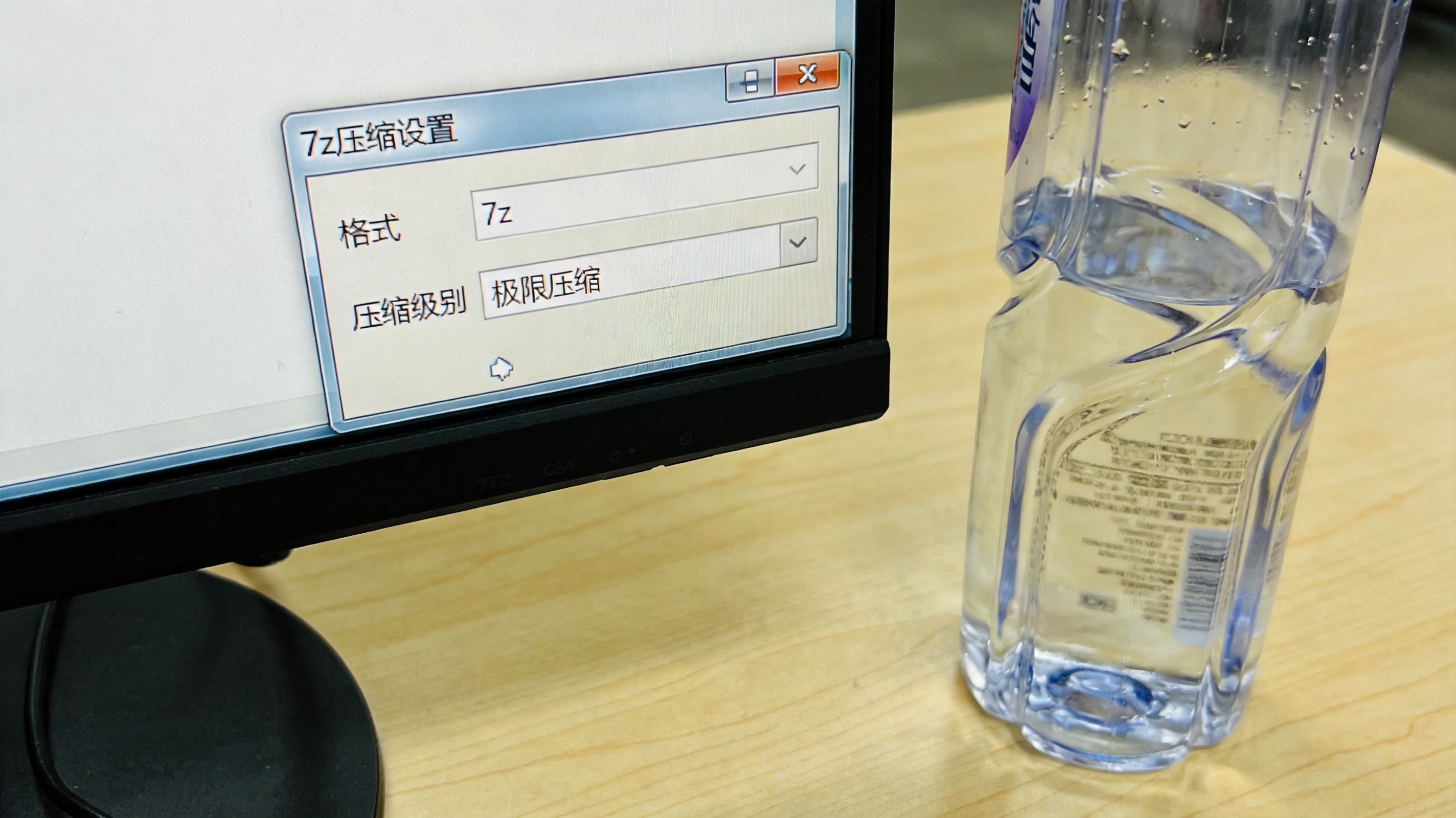 电脑桌面，屏幕显示7z压缩设置窗口，格式选7z，压缩级别设为极限压缩，旁边放着半瓶矿泉水，室内自然光