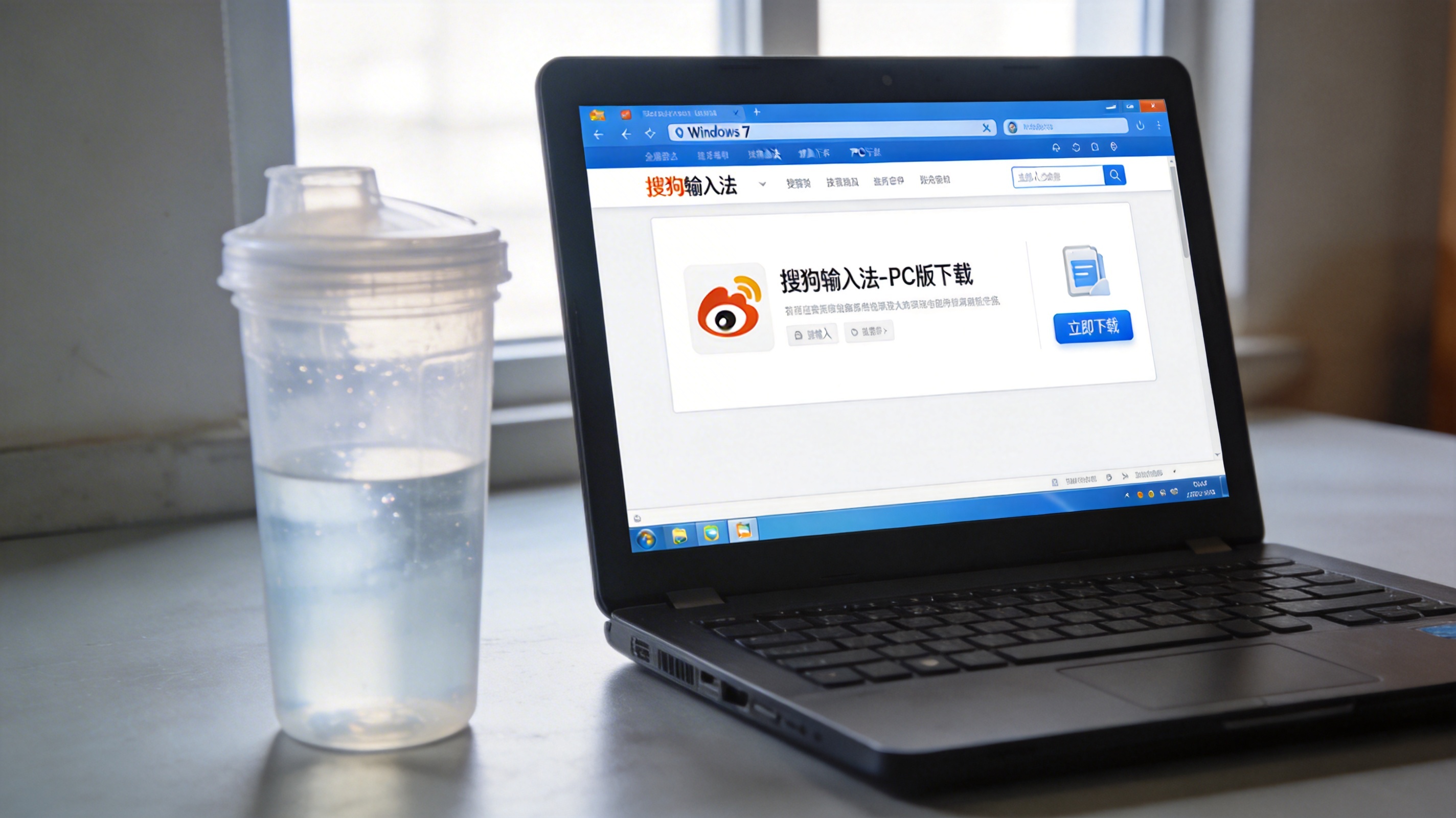 Windows 7系统的电脑桌面，屏幕显示搜狗输入法官网的PC版下载页面，旁边放着半透明塑料水杯，室内自然光