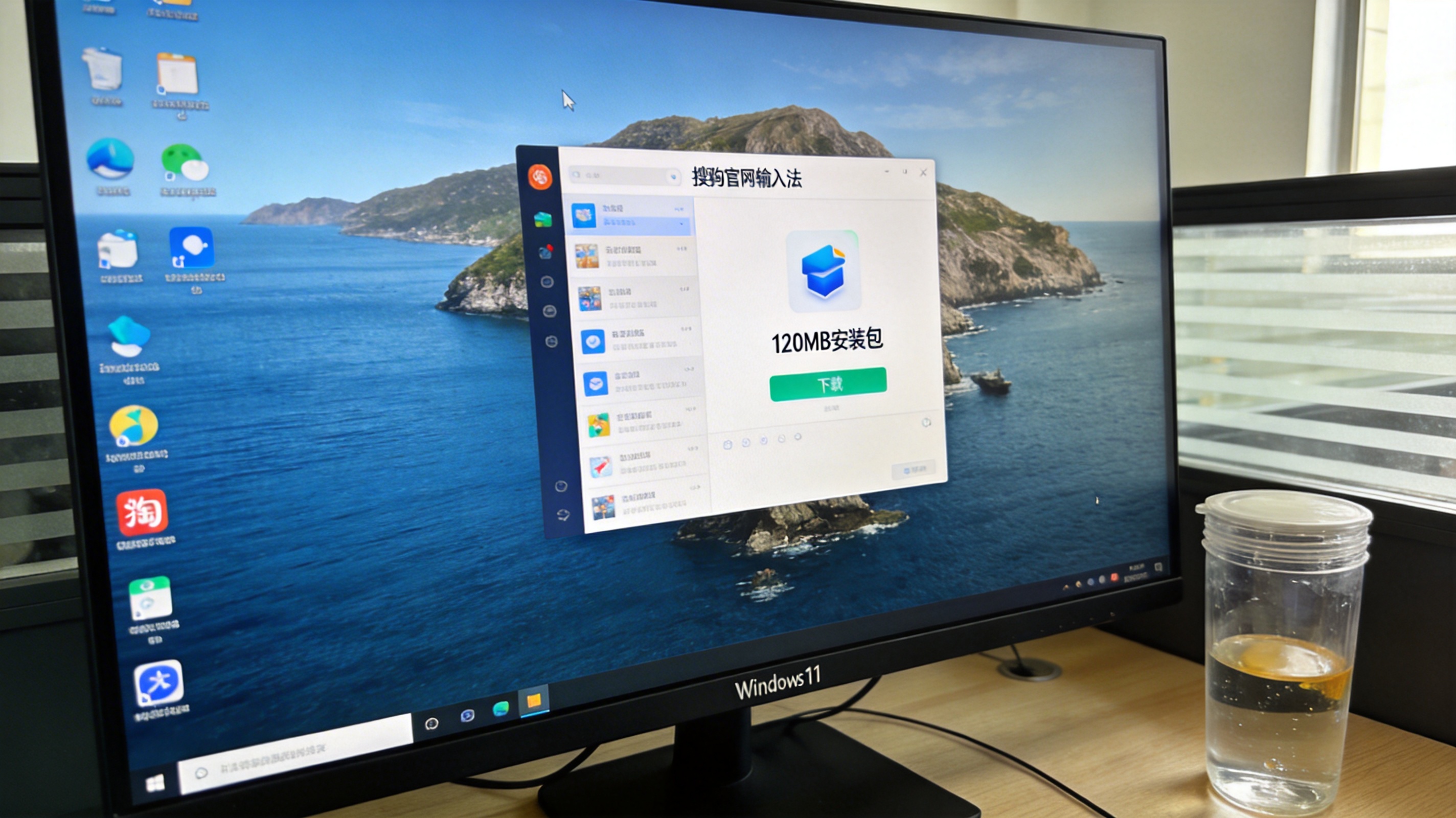 电脑桌前的Windows11系统电脑，屏幕显示搜狗官网输入法板块的下载窗口，标注120MB安装包，桌面放着半透明水杯，室内自然光