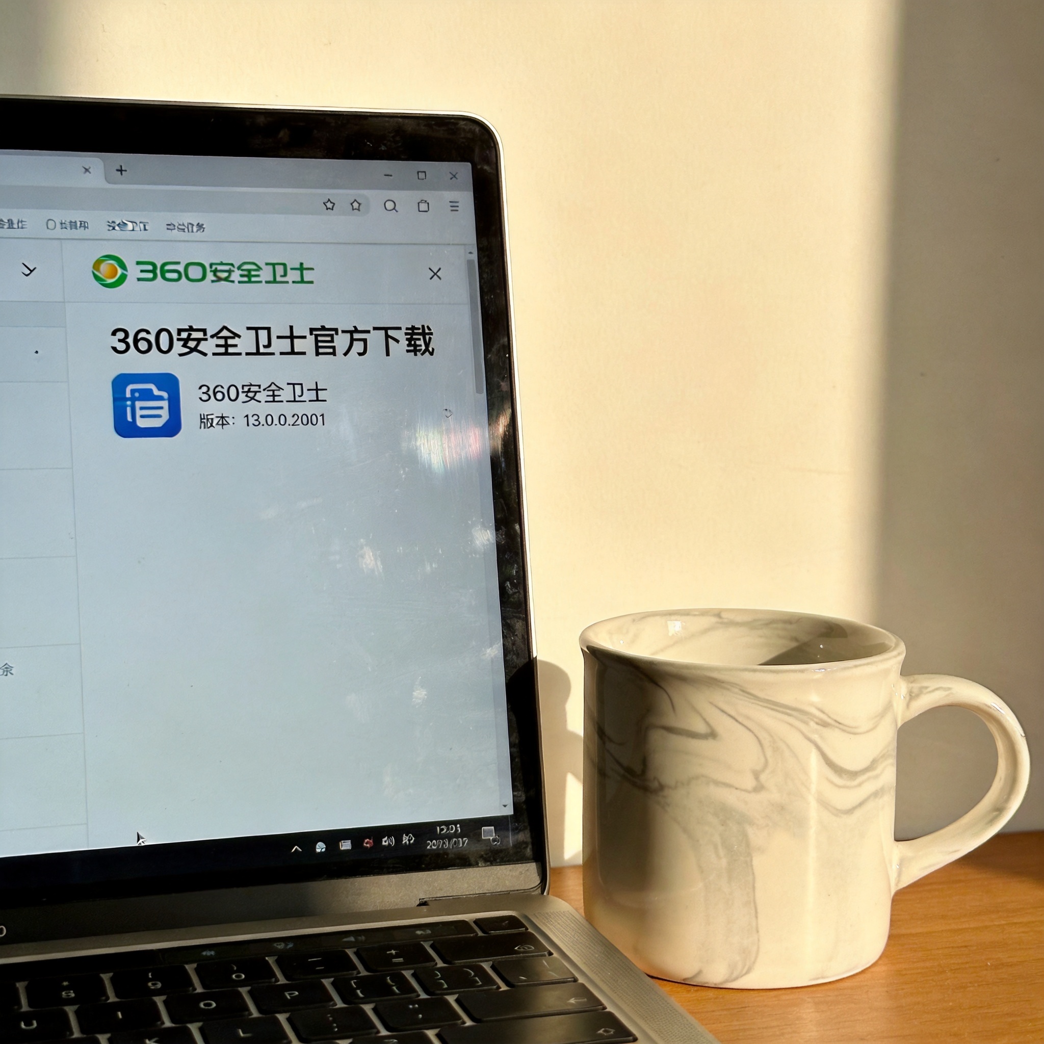 电脑桌的电脑屏幕显示360安全卫士官方下载页面，页面带有官方logo和版本说明，旁边放着陶瓷水杯，室内自然光
