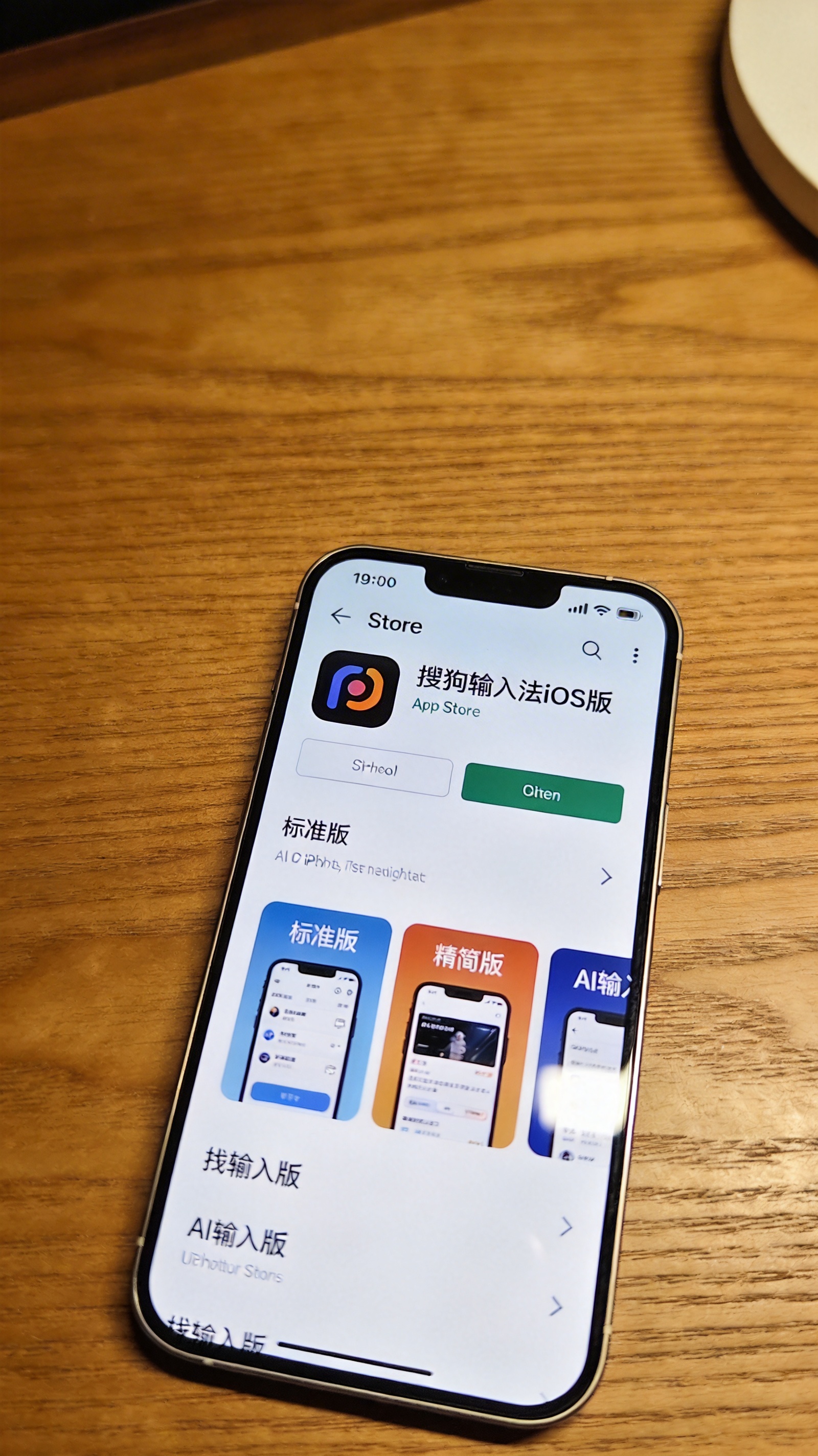 桌面上的iPhone，屏幕显示App Store里的搜狗输入法iOS版下载页面，能看到标准版、精简版、AI输入版三个选项，室内自然光