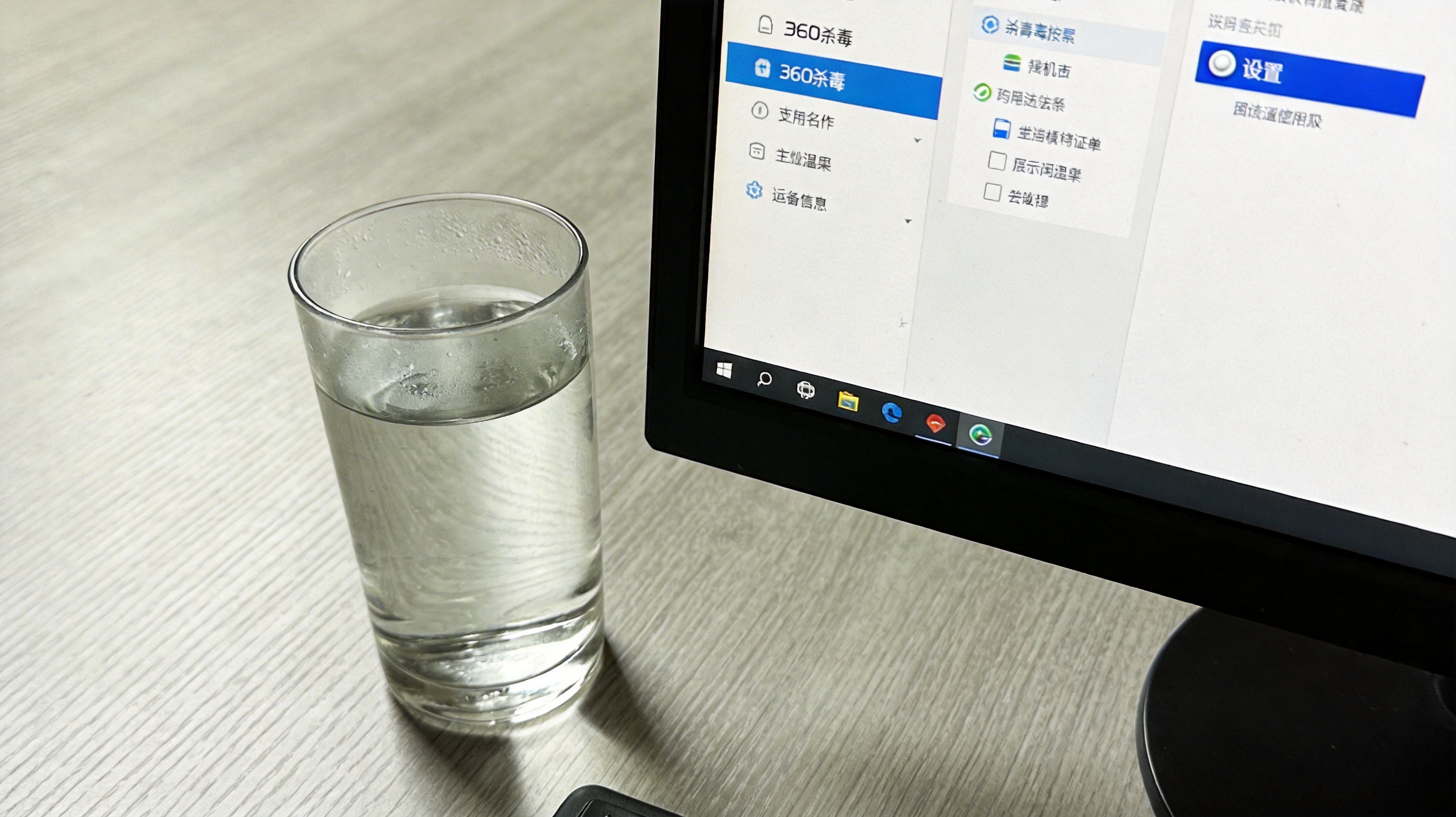 电脑桌面，屏幕显示360杀毒软件主界面，右上角设置按钮处于选中状态，旁边放着半杯温水，室内自然光