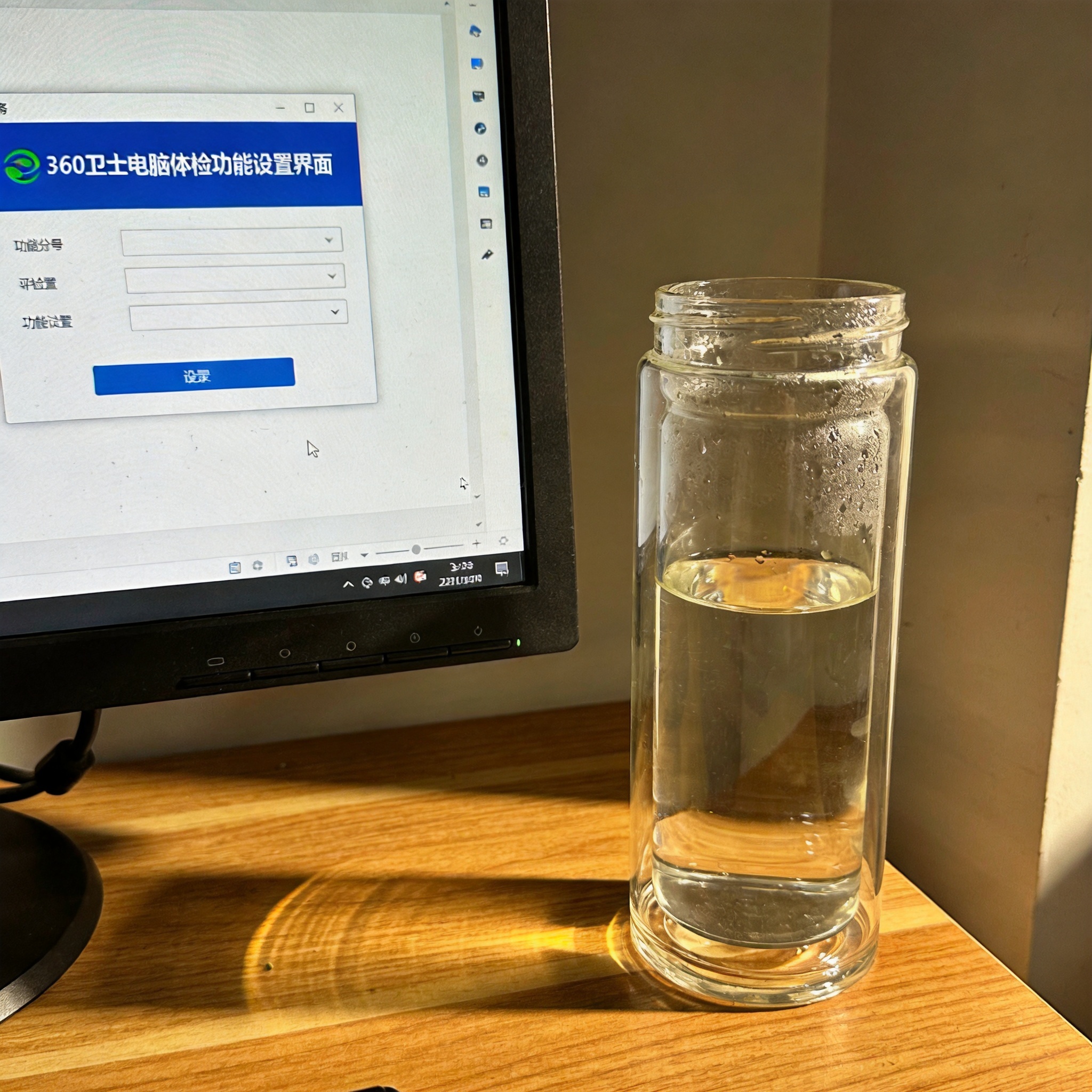 书桌上的电脑，屏幕显示360 卫士电脑体检功能设置界面，桌角放着水杯，自然光