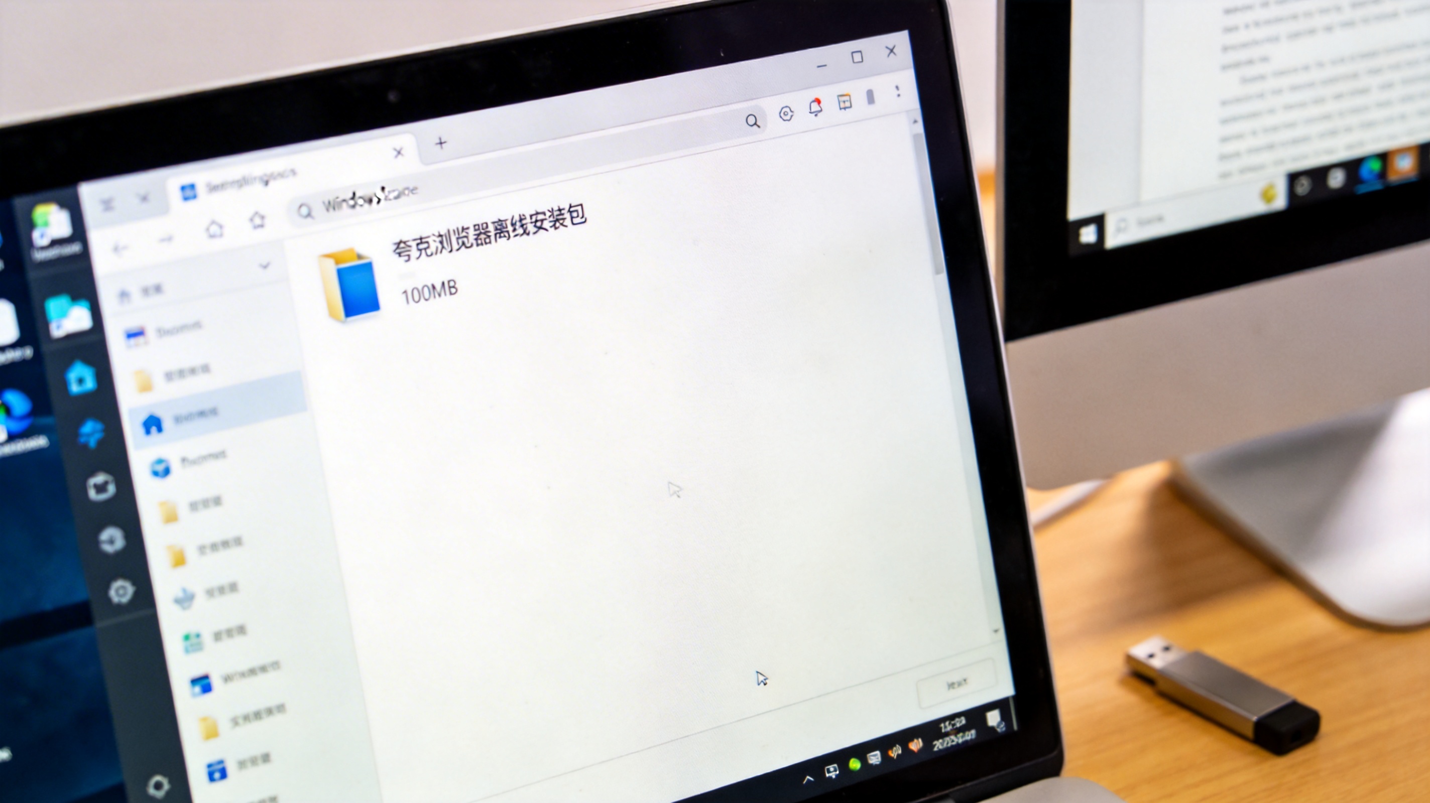 办公电脑桌面，屏幕显示Windows系统的文件资源管理器，里面有100MB大小的夸克浏览器离线安装包，旁边放着U盘，室内自然光