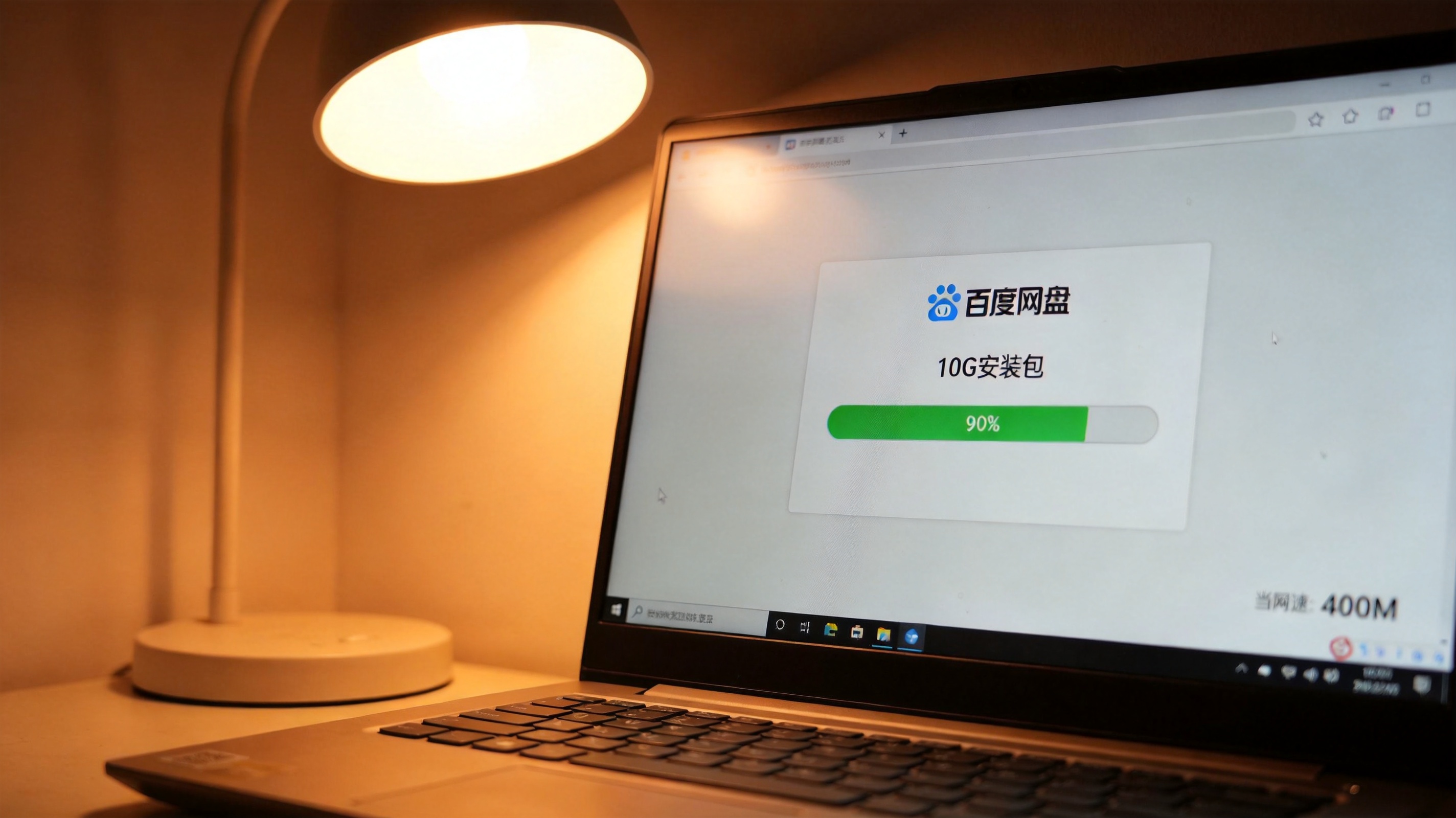 电脑屏幕显示百度网盘下载界面，10G安装包下载进度条已完成90%，桌面右下角显示当前网速为400M，台灯暖光