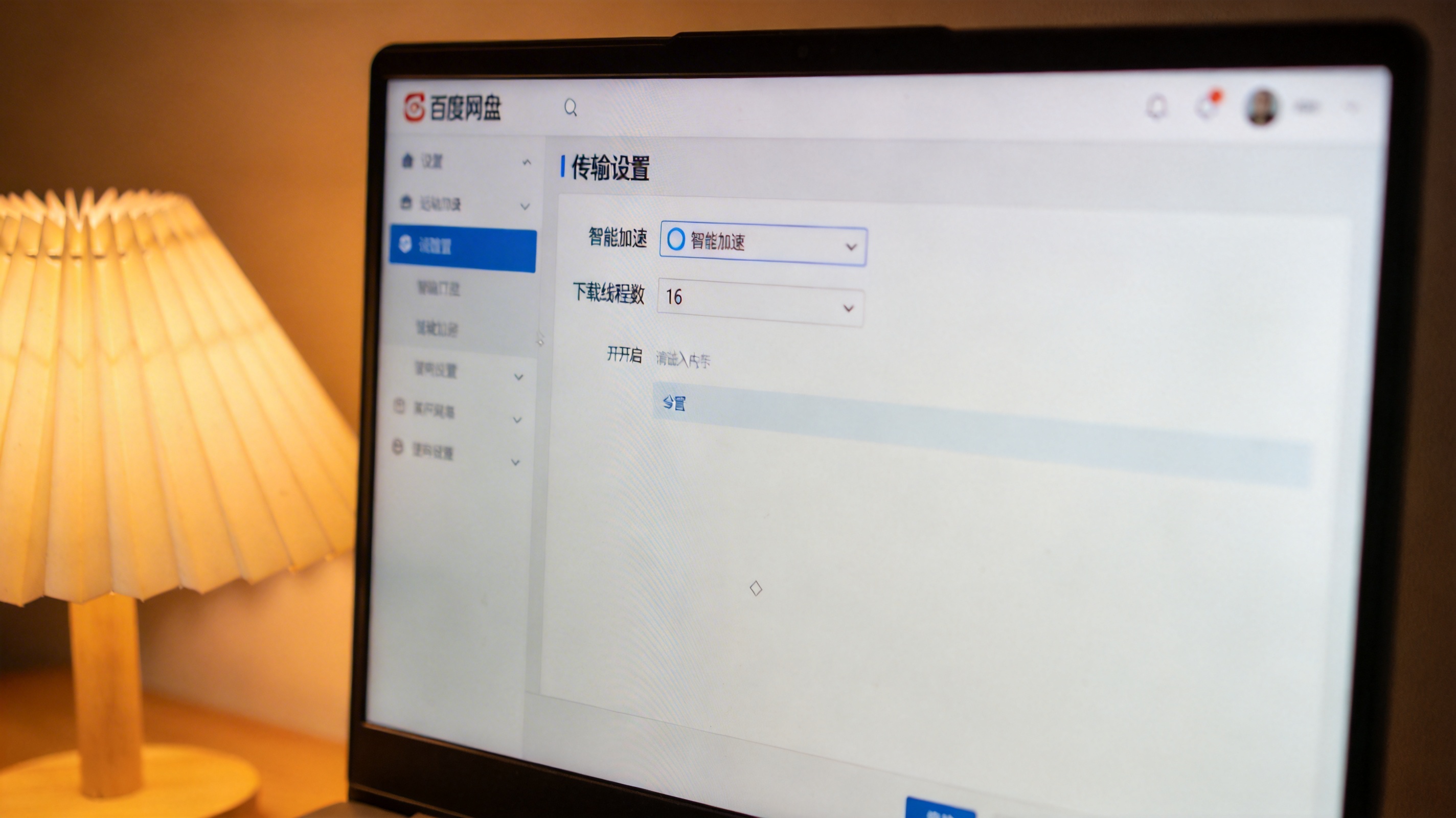 电脑屏幕显示百度网盘设置界面，传输设置栏里的智能加速选项已开启，下载线程数调到16，台灯暖光