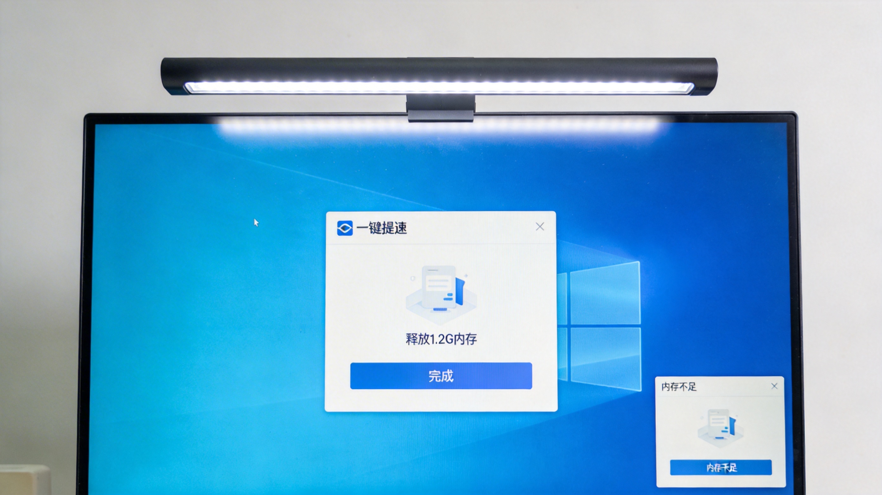 电脑屏幕显示百度网盘“一键提速”完成界面，标注释放1.2G内存，桌面右下角有内存不足提示弹窗，台灯冷光