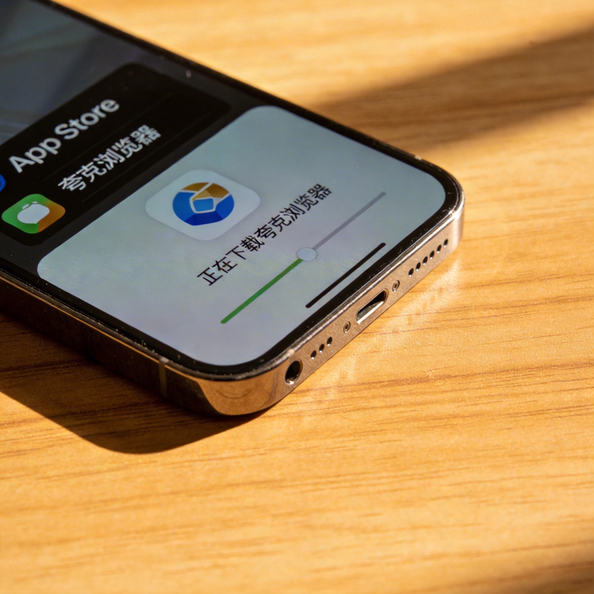 苹果手机放在木质桌面上，屏幕显示App Store里夸克浏览器的下载界面，室内自然光