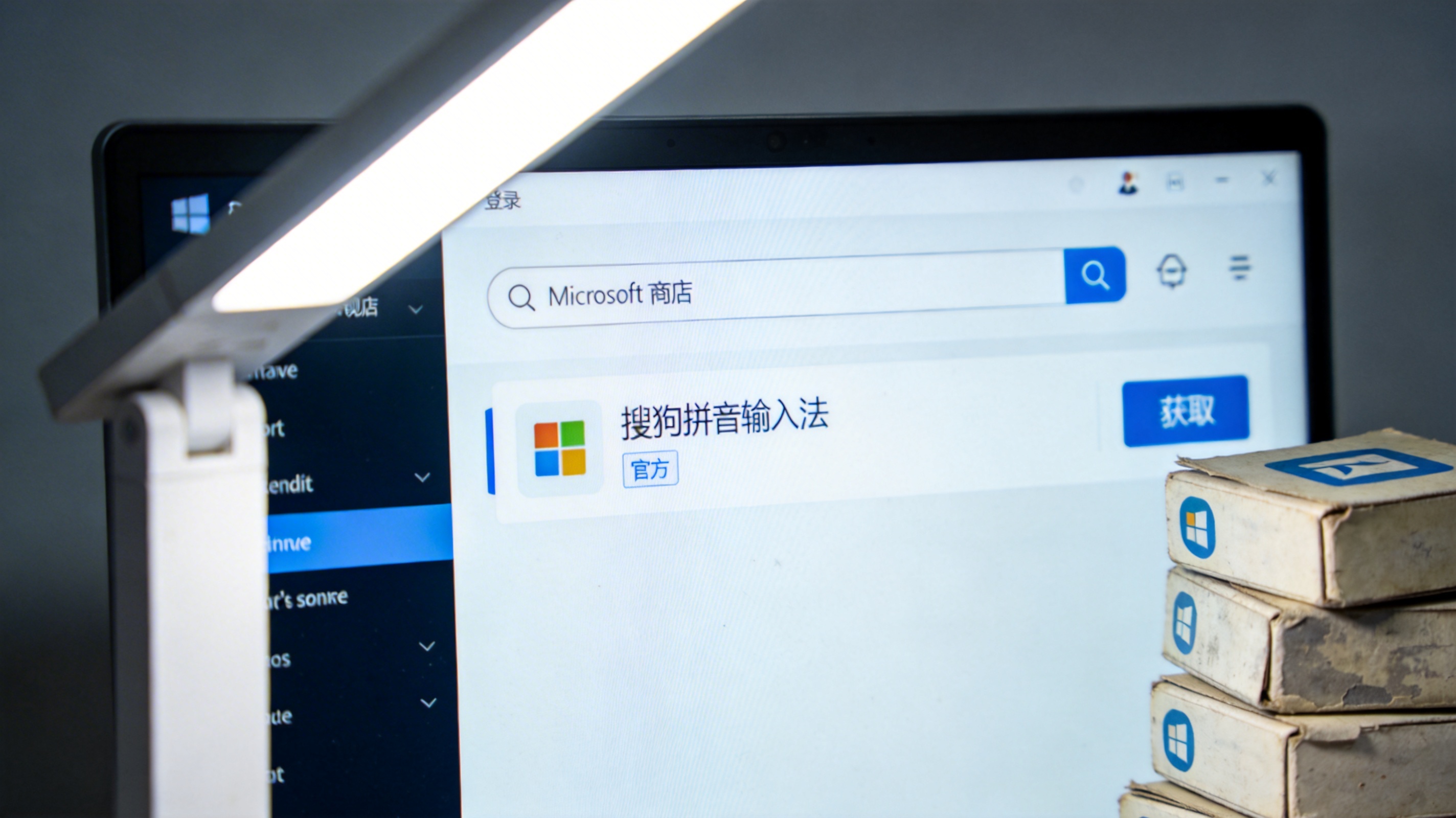 台式电脑屏幕显示微软商店界面，搜索栏下方出现带官方标识的搜狗拼音输入法，右侧显示获取按钮，旁边堆着几个旧安装包，台灯冷白光
