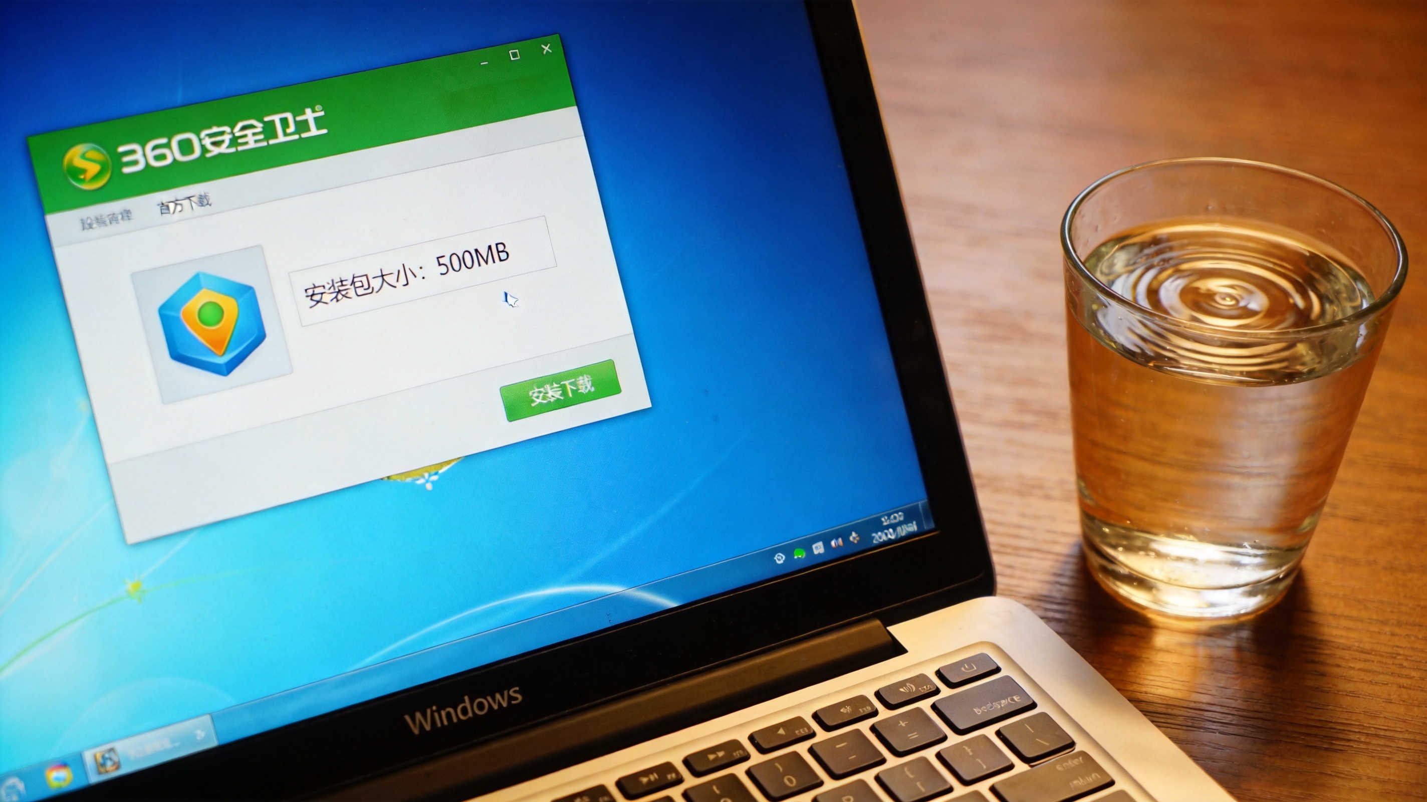 Windows系统的电脑桌面，屏幕显示360安全卫士官方下载页面，页面标注安装包大小为500MB，桌面放着半杯温水，室内自然光
