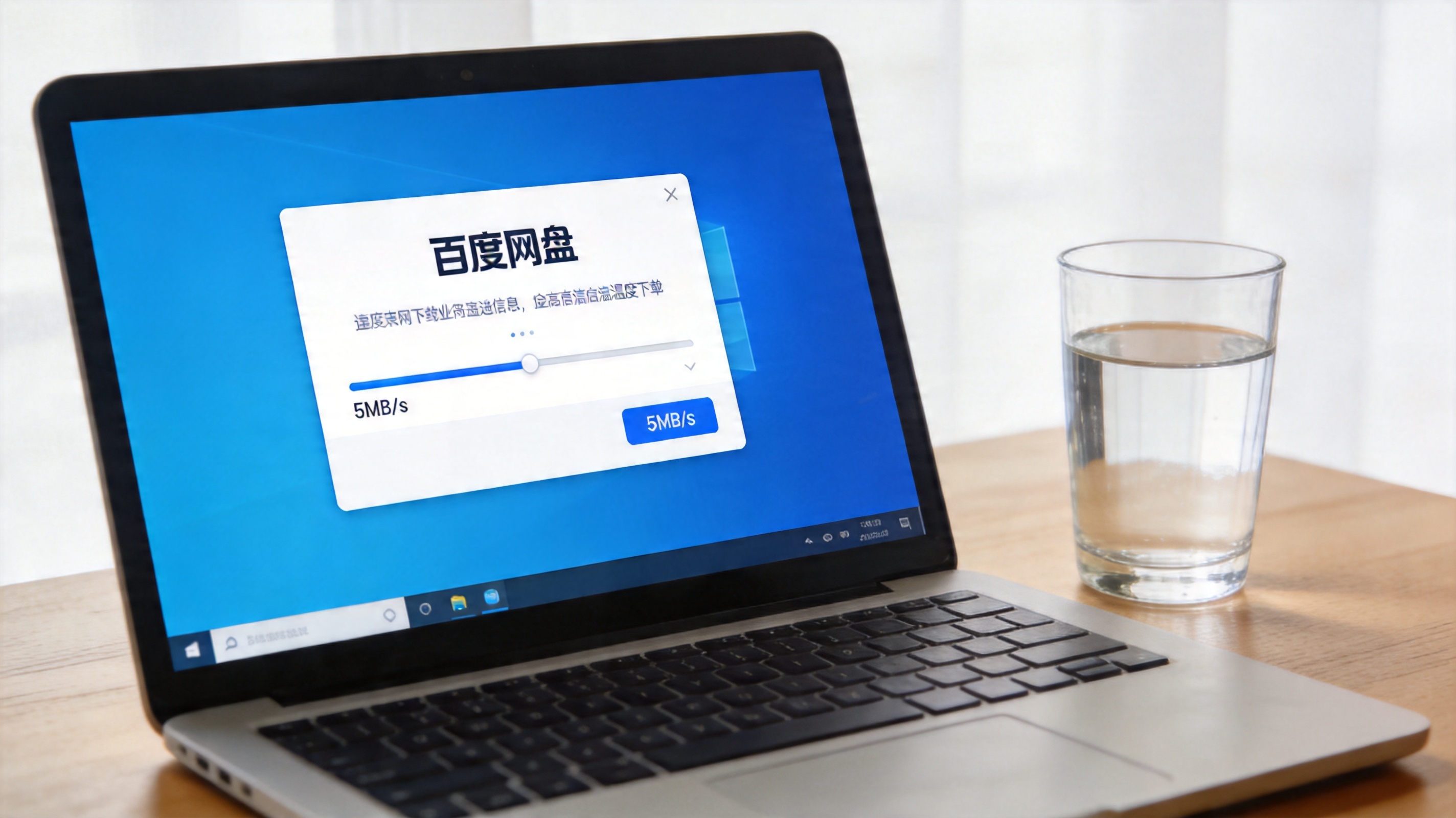 电脑桌面，屏幕显示百度网盘下载界面，进度条旁显示下载速度5MB每秒，桌面放着半杯温水，室内自然光