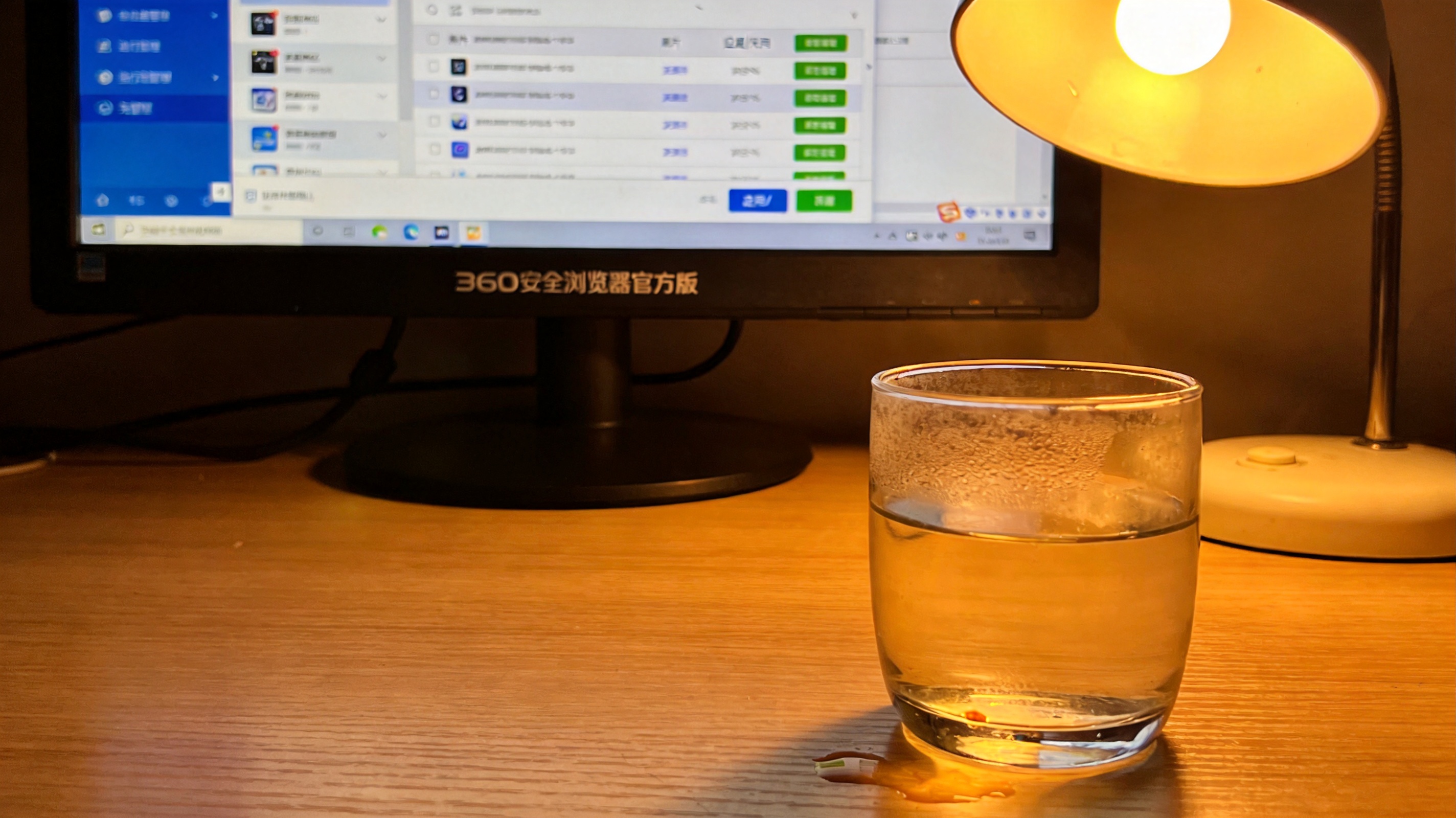 电脑屏幕显示360安全浏览器官方版的插件管理界面，桌面角落放着半杯温水，台灯暖光