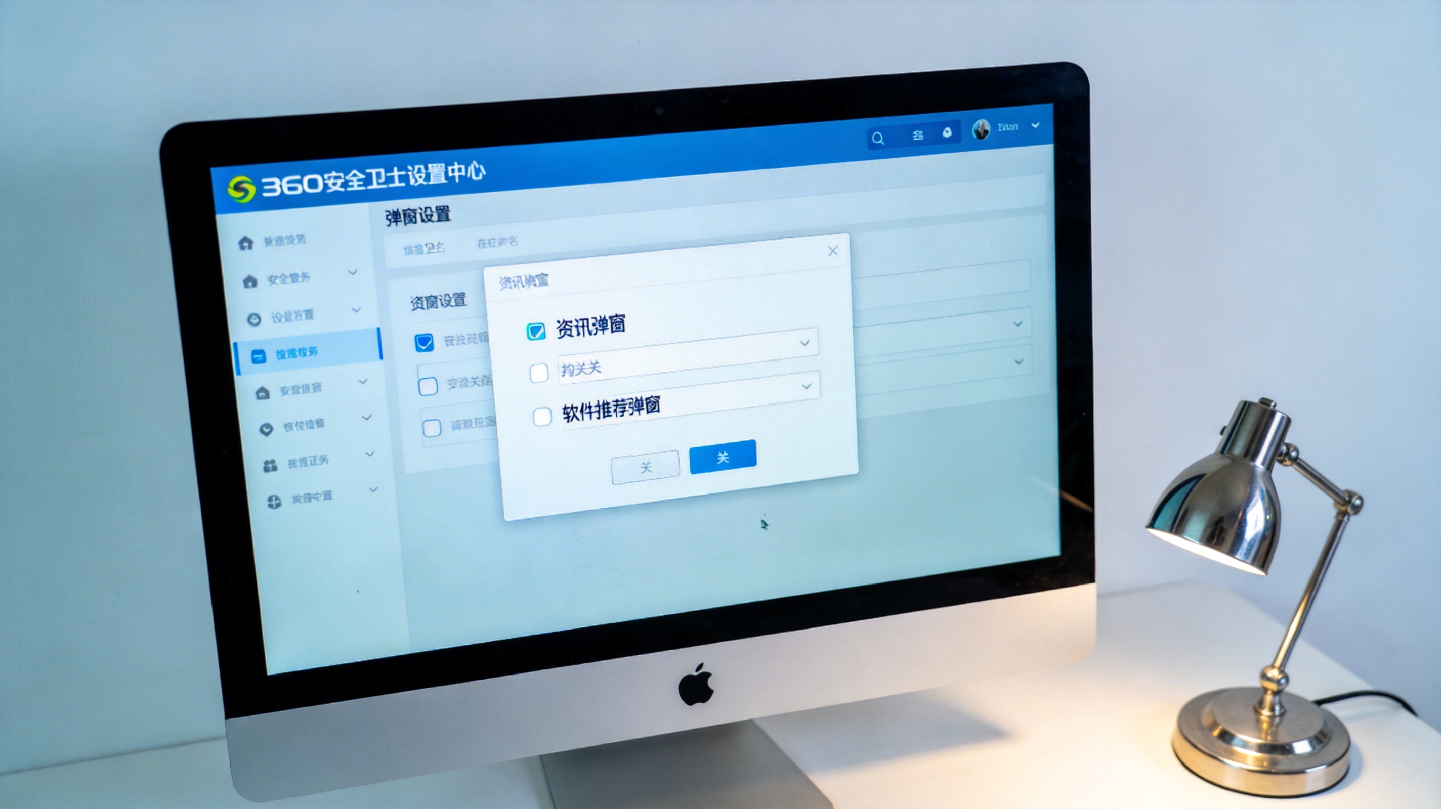 电脑屏幕显示360安全卫士设置中心的弹窗设置页面，资讯弹窗、软件推荐弹窗选项已勾选关闭，桌面角落有台金属台灯