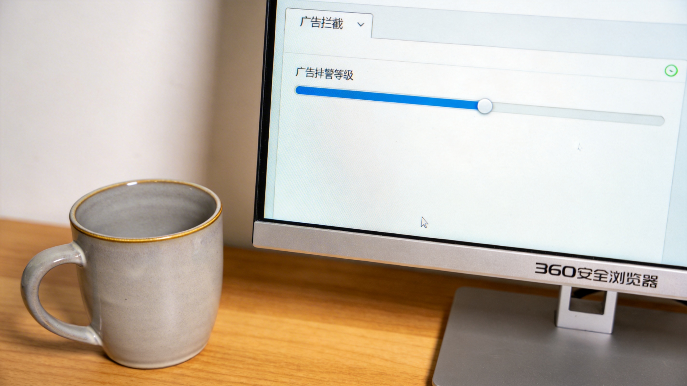 电脑桌面，屏幕显示360安全浏览器电脑版的设置界面，广告拦截等级调至最高，旁边放着陶瓷水杯，室内自然光