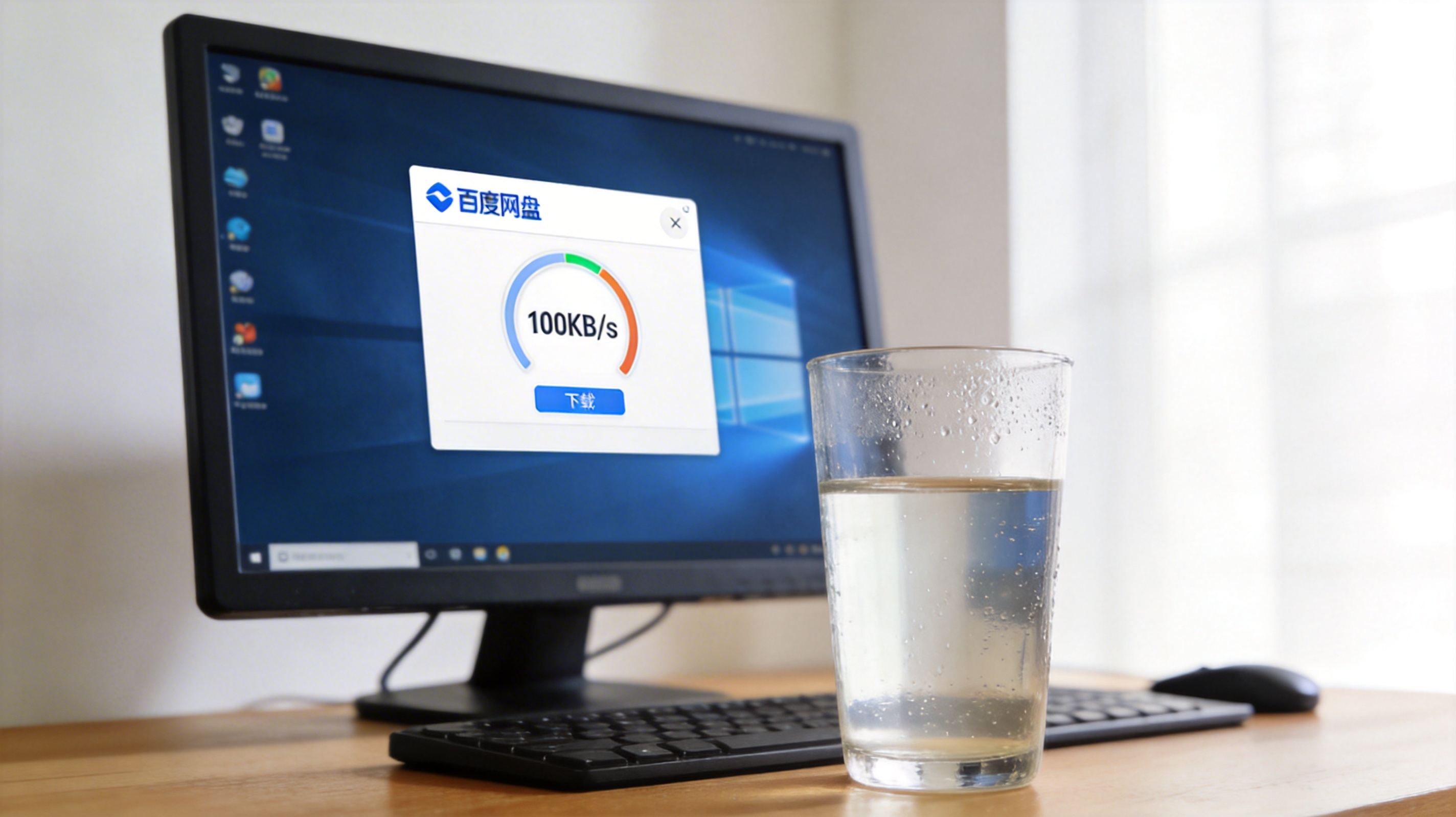 电脑桌面，屏幕显示百度网盘客户端界面，下载速度显示100KB/s，旁边放着半杯温水，室内自然光