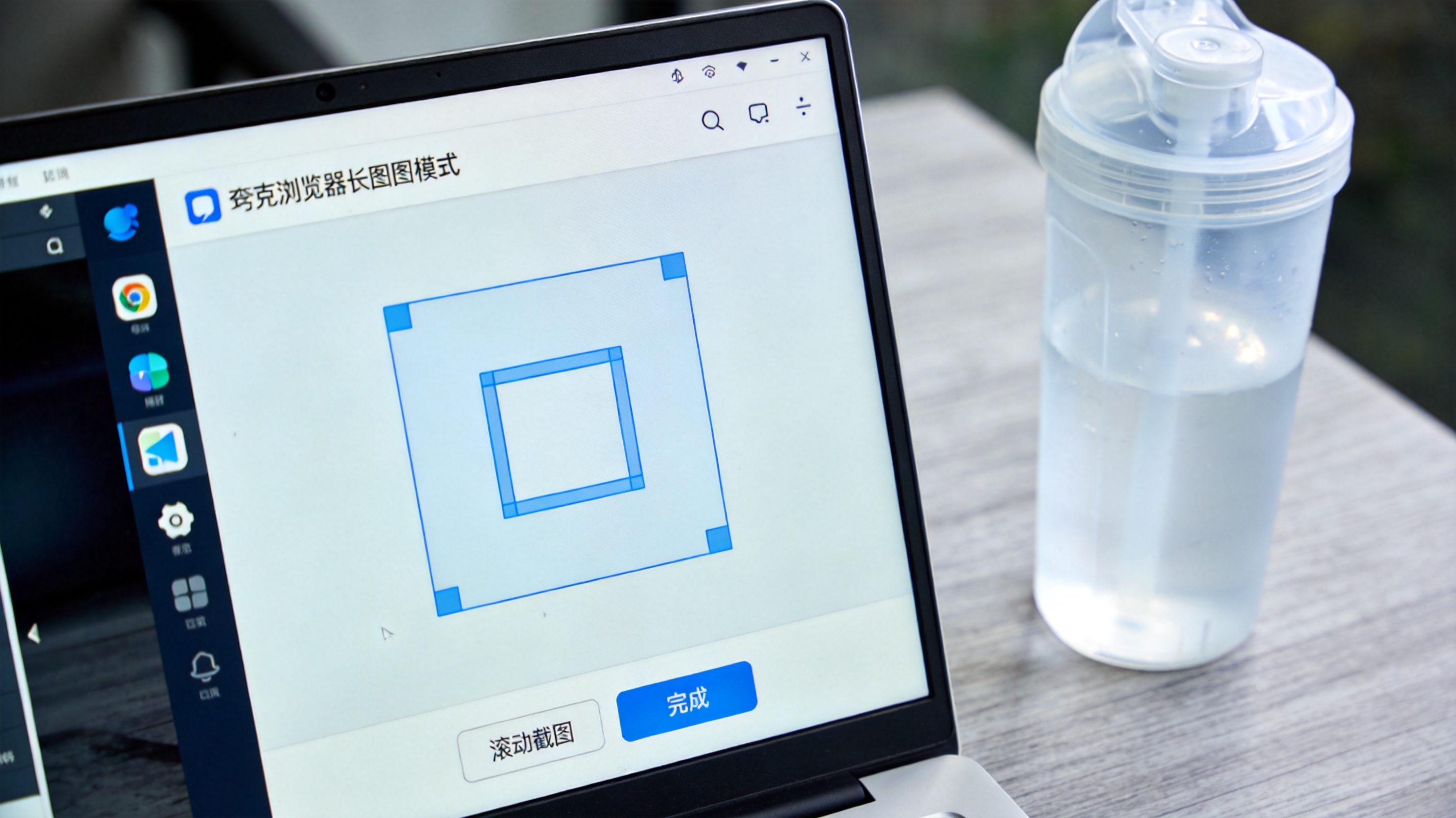 电脑屏幕显示夸克浏览器长截图模式界面，画面里有可调的选框，下方出现“滚动截图”“完成”按钮，桌面放着半透明塑料水杯