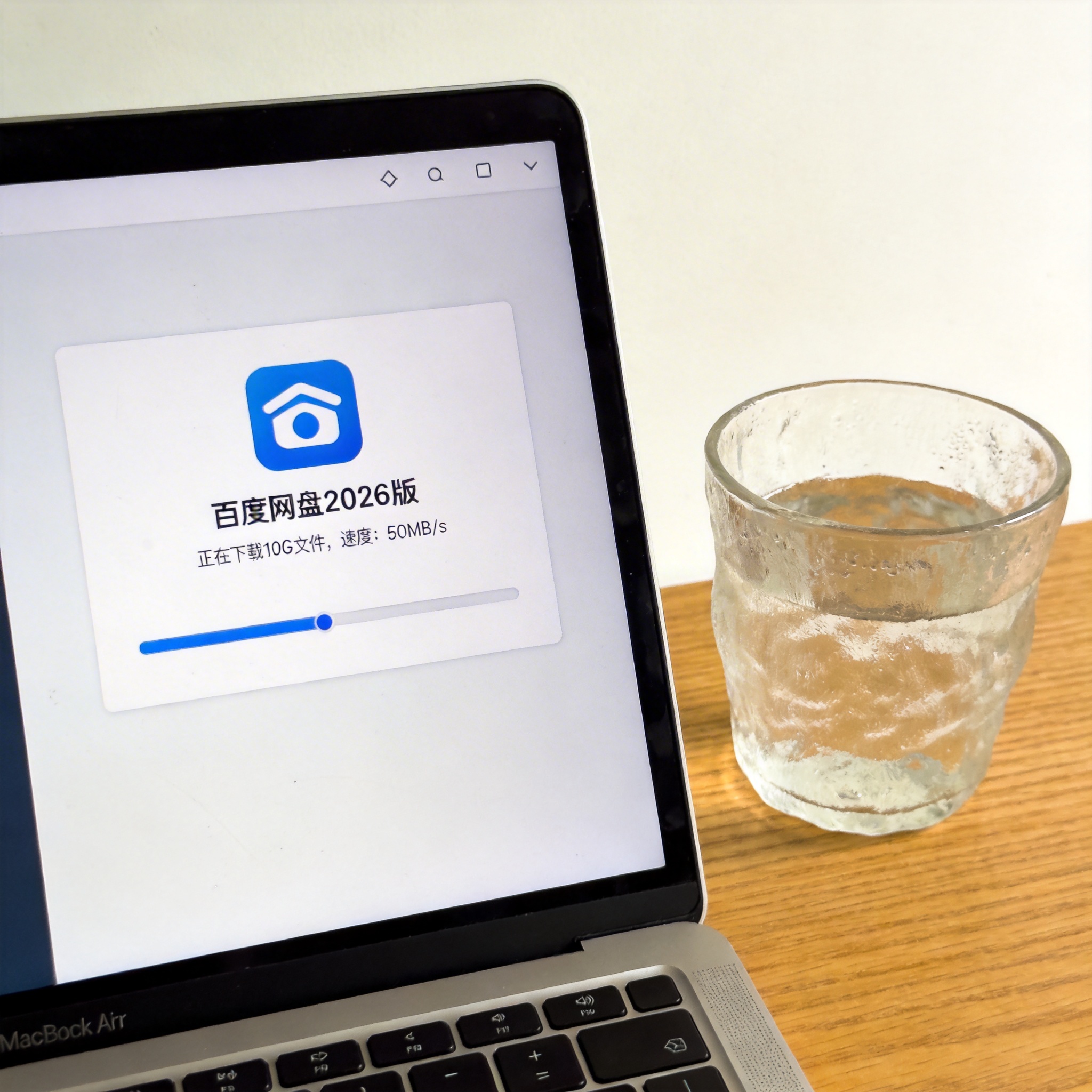 电脑桌的电脑屏幕显示百度网盘2026版下载界面，正在下载10G文件，速度显示50MB/s，旁边放着半杯温水，室内自然光