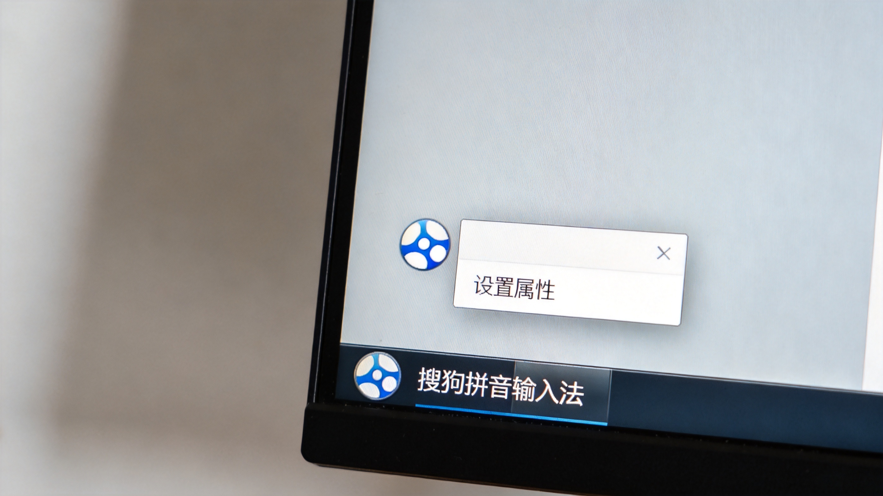 电脑桌面，屏幕显示任务栏上的搜狗拼音输入法图标，右键弹出的菜单里显示“设置属性”选项，室内自然光
