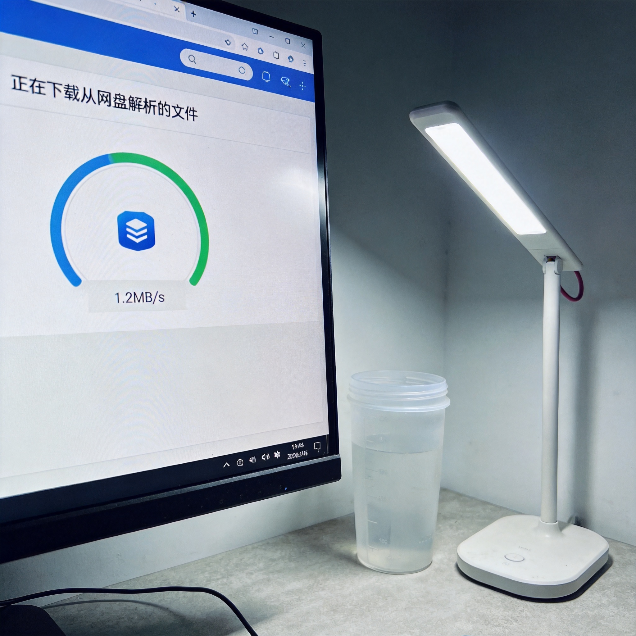 电脑屏幕显示迅雷下载界面，正在下载从网盘解析的文件，速度显示1.2MB/s，桌面角落有个普通塑料水杯，台灯冷光