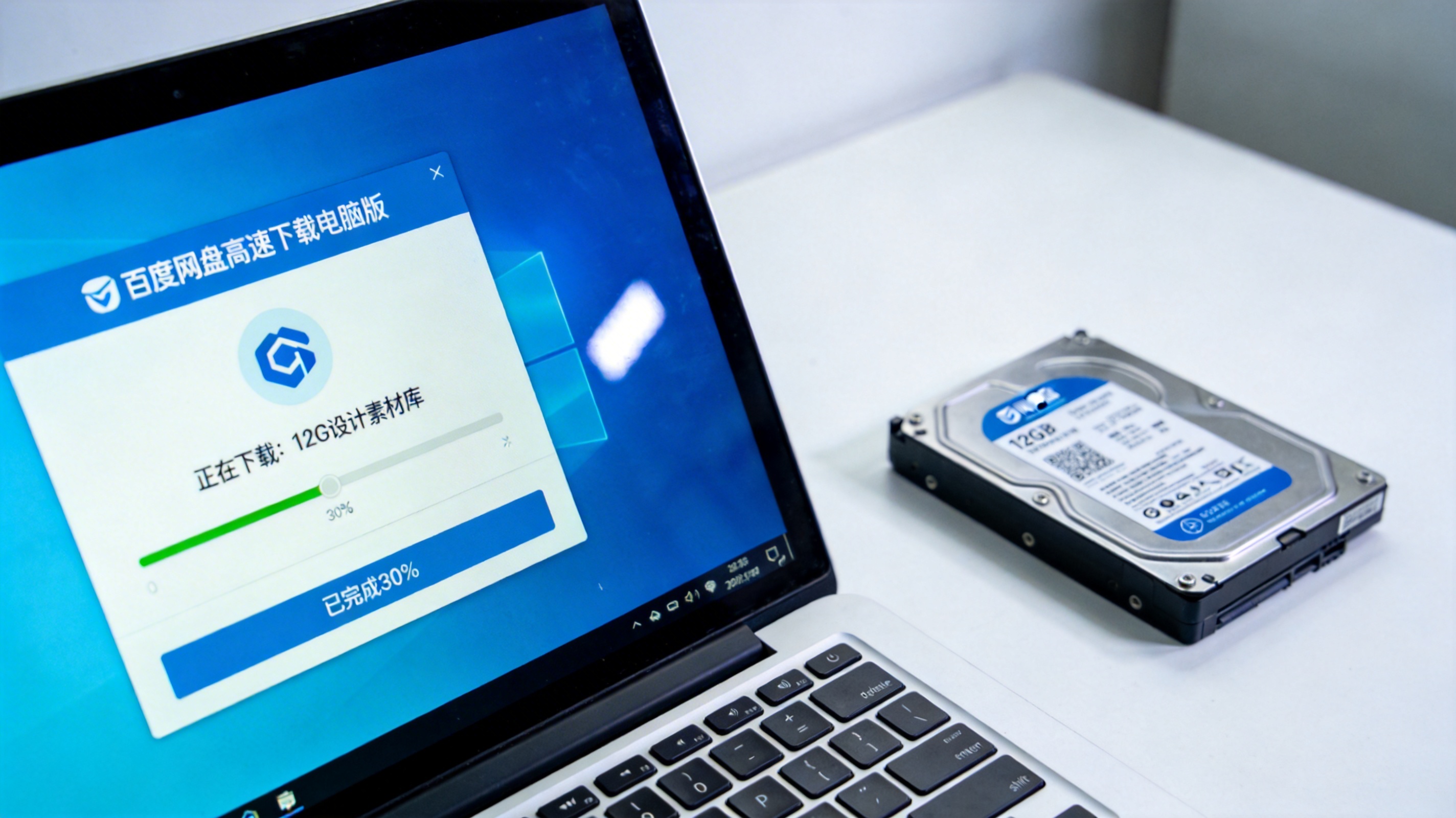 电脑桌面，屏幕显示百度网盘高速下载电脑版界面，正在下载12G设计素材库，进度条显示已完成30%，旁边放着硬盘