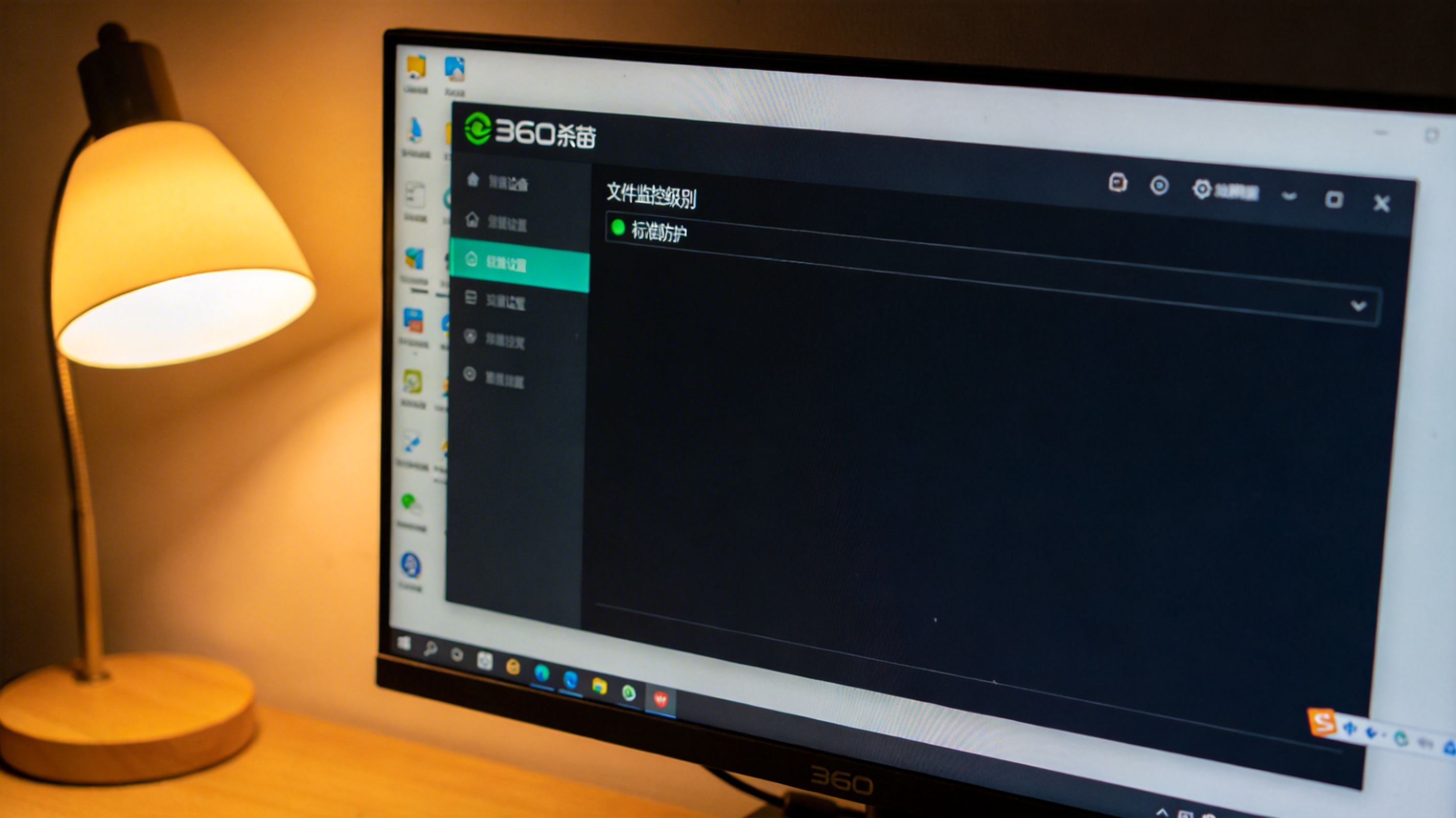 台式机屏幕显示360杀毒设置界面，“文件监控级别”选项调至标准防护，桌面角落有台灯暖光