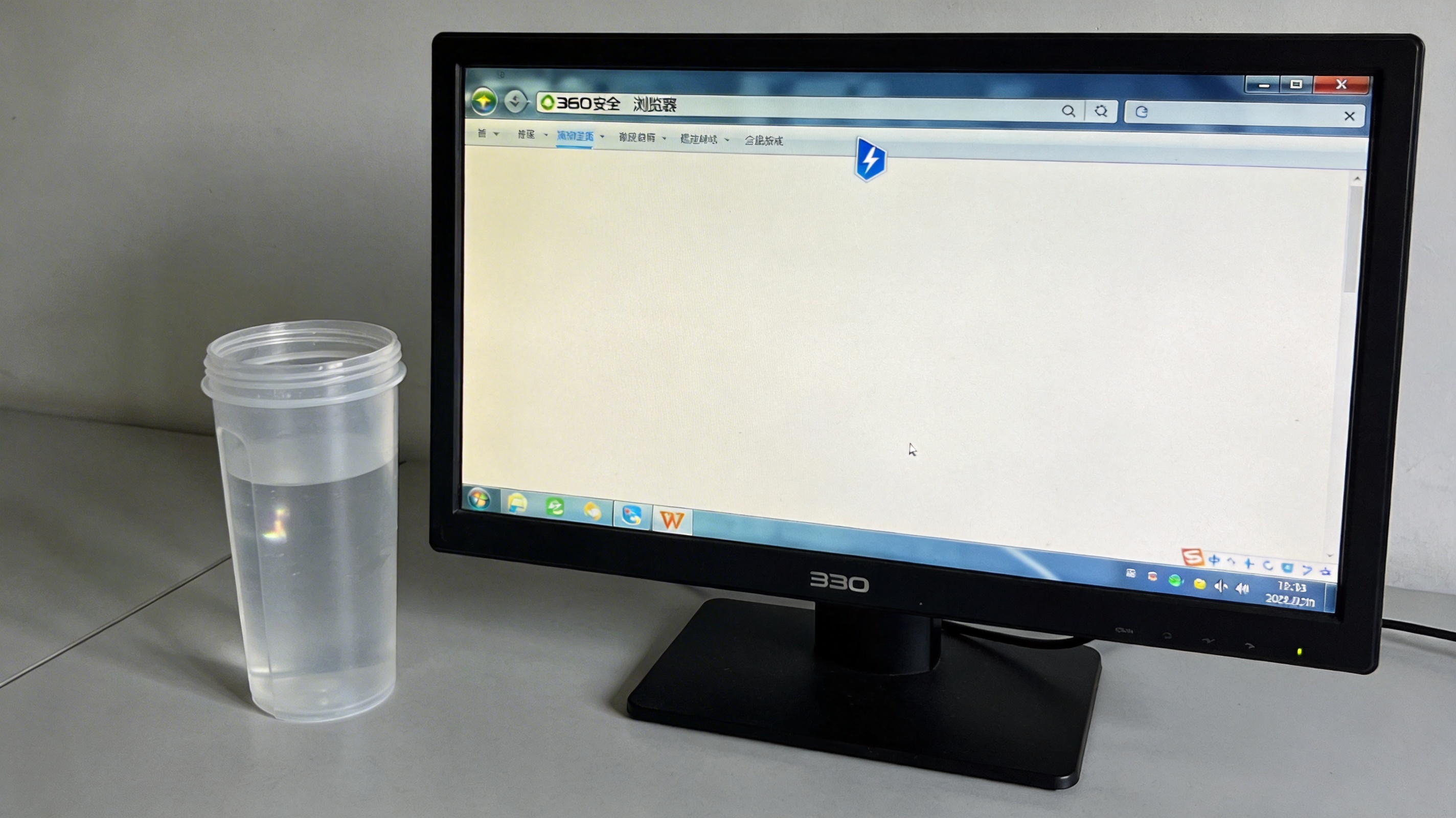 电脑桌面，屏幕显示360安全浏览器界面，地址栏右侧显示闪电图标，旁边放着半透明塑料水杯，室内自然光