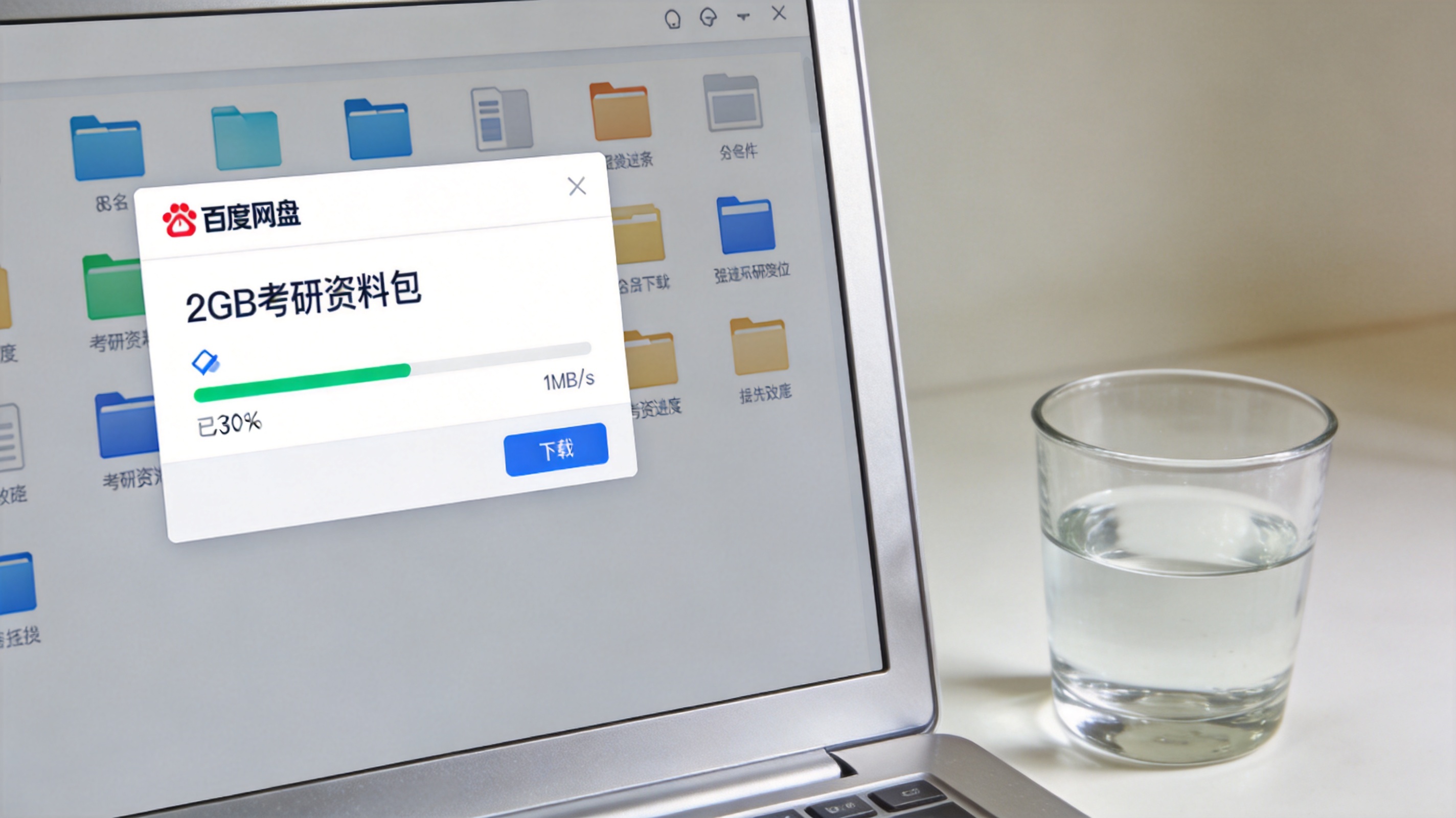 电脑桌面，屏幕显示百度网盘下载界面，2GB考研资料包下载速度稳定在1MB/s，旁边放着半杯清水，室内自然光