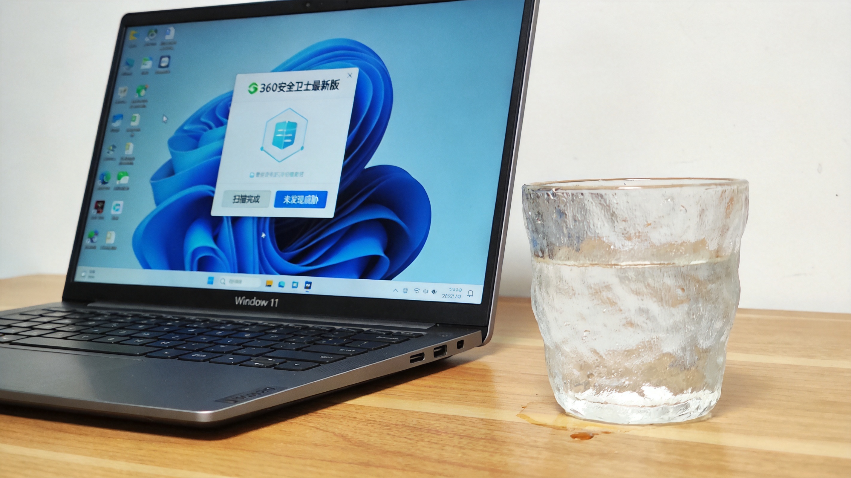 电脑桌的Windows11系统电脑，屏幕显示360安全卫士最新版的全盘查杀结果界面，桌面放着半杯凉白开，室内自然光