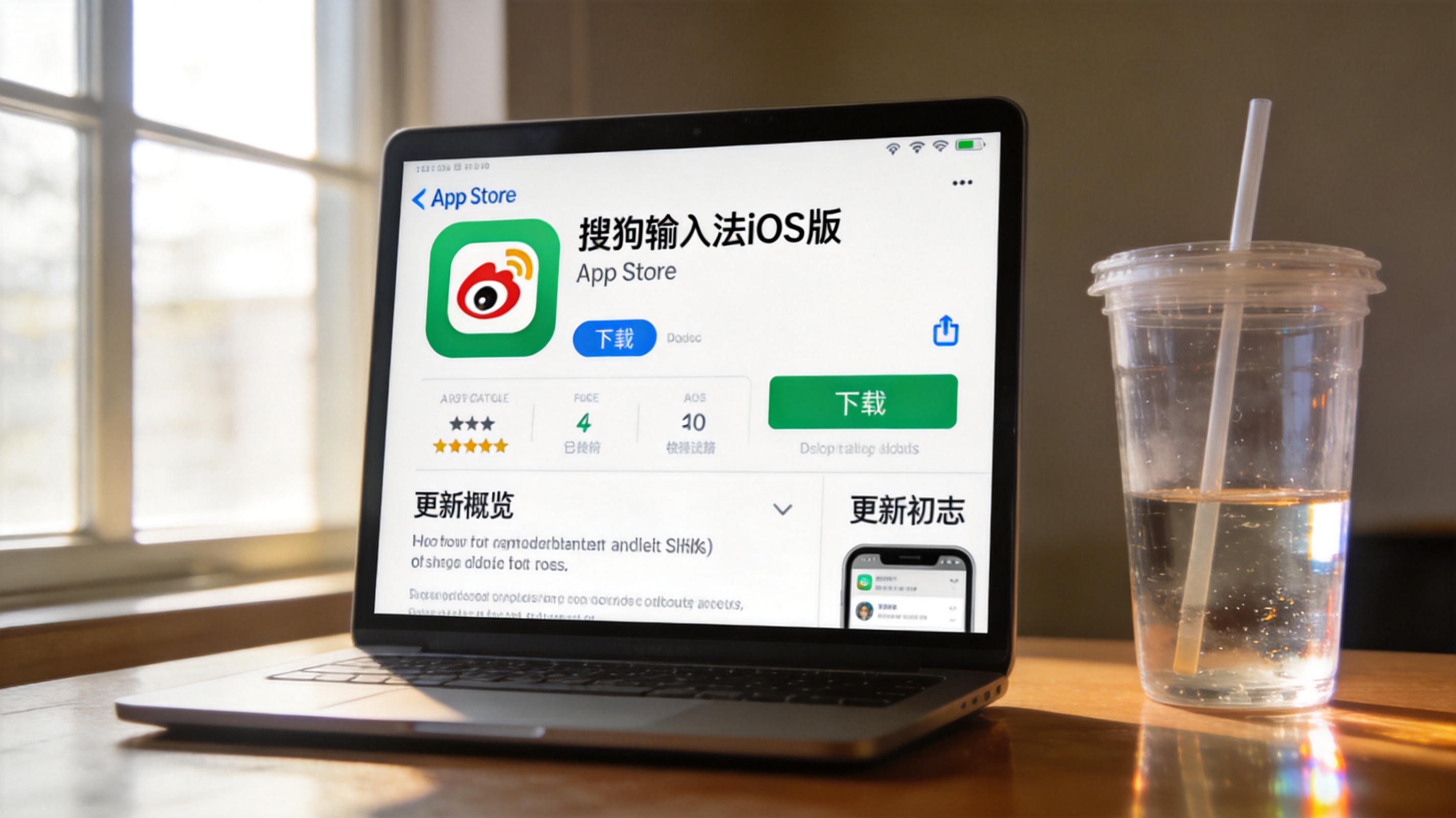 电脑桌面，屏幕显示App Store里的搜狗输入法iOS版下载界面，旁边放着半透明塑料水杯，室内自然光