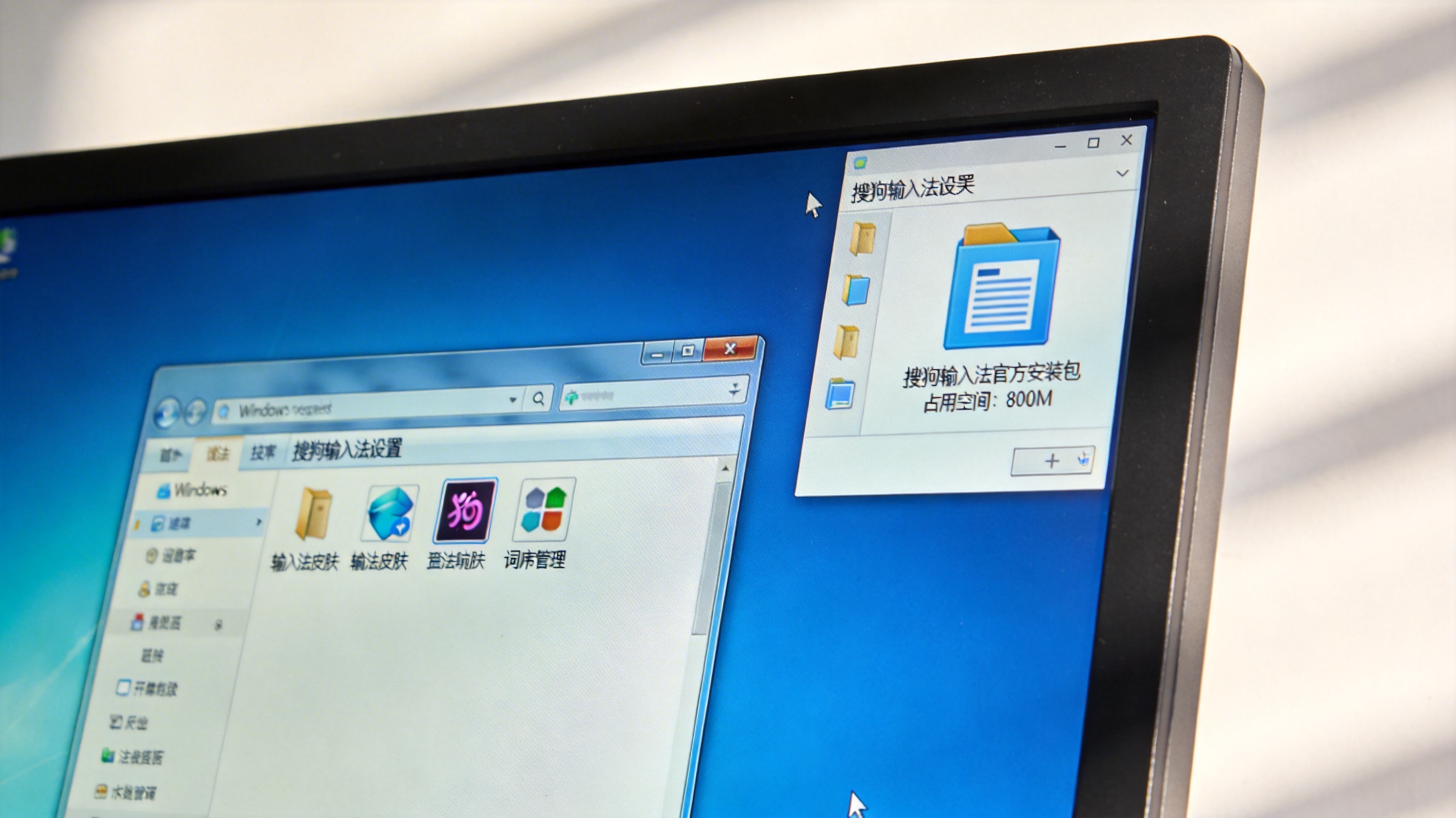 电脑桌面，屏幕显示Windows系统的搜狗输入法设置界面，旁边的文件夹里显示官方安装包占用800M内存，室内自然光