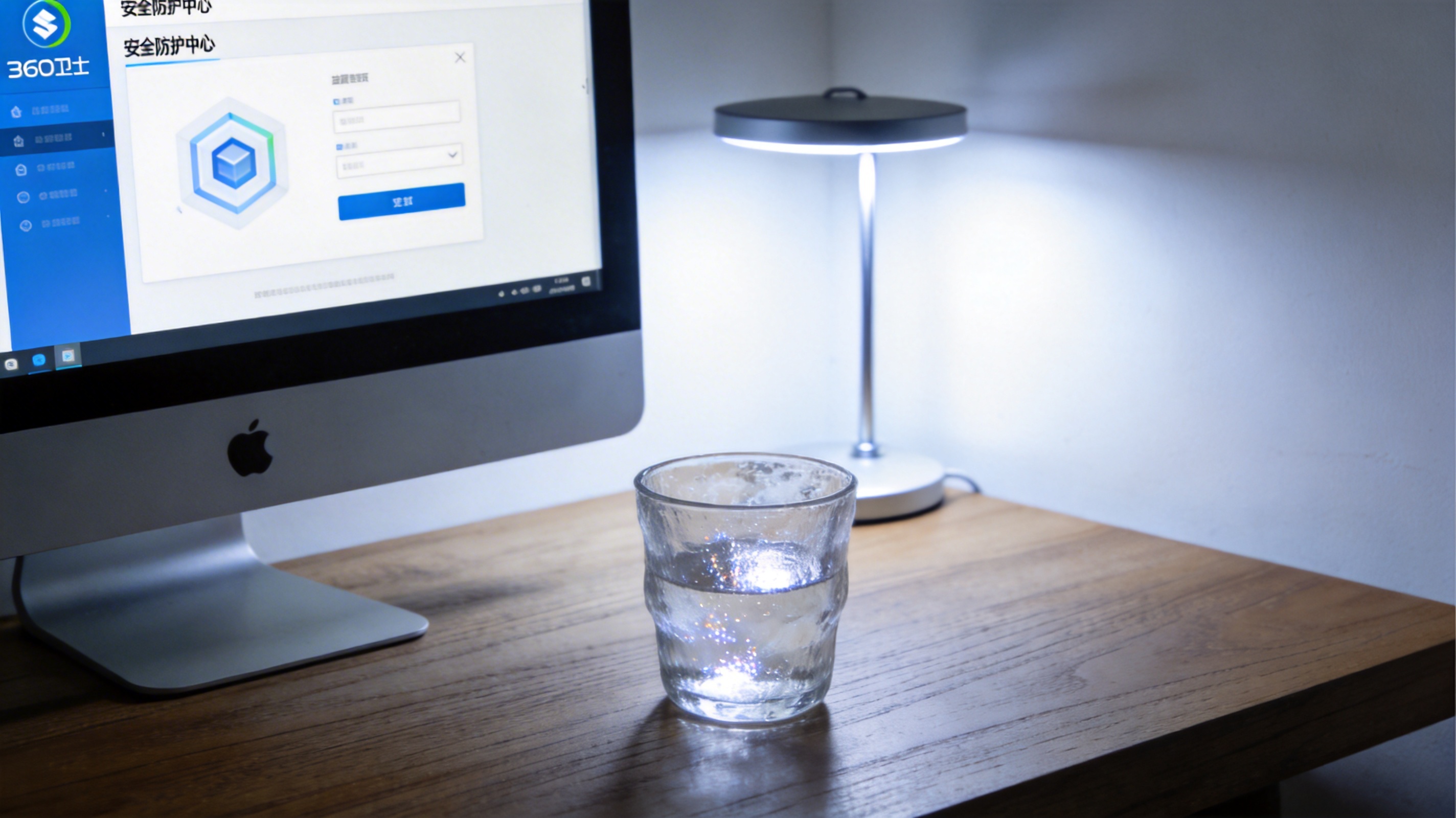 电脑屏幕显示360卫士主界面，首页有安全防护中心入口，桌面角落放着玻璃杯，台灯冷光