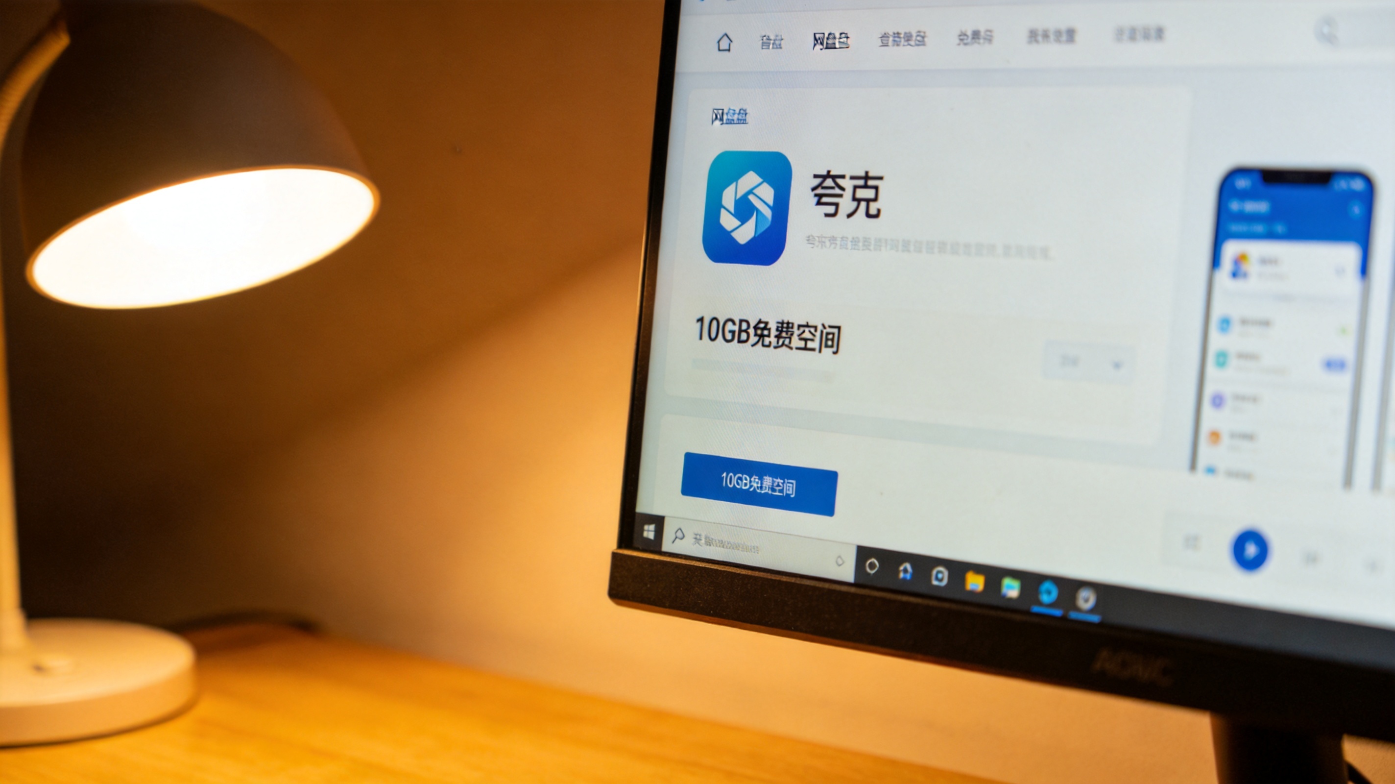 电脑屏幕显示夸克APP网盘界面，页面标注10GB免费空间，桌面角落有台灯，暖光照射