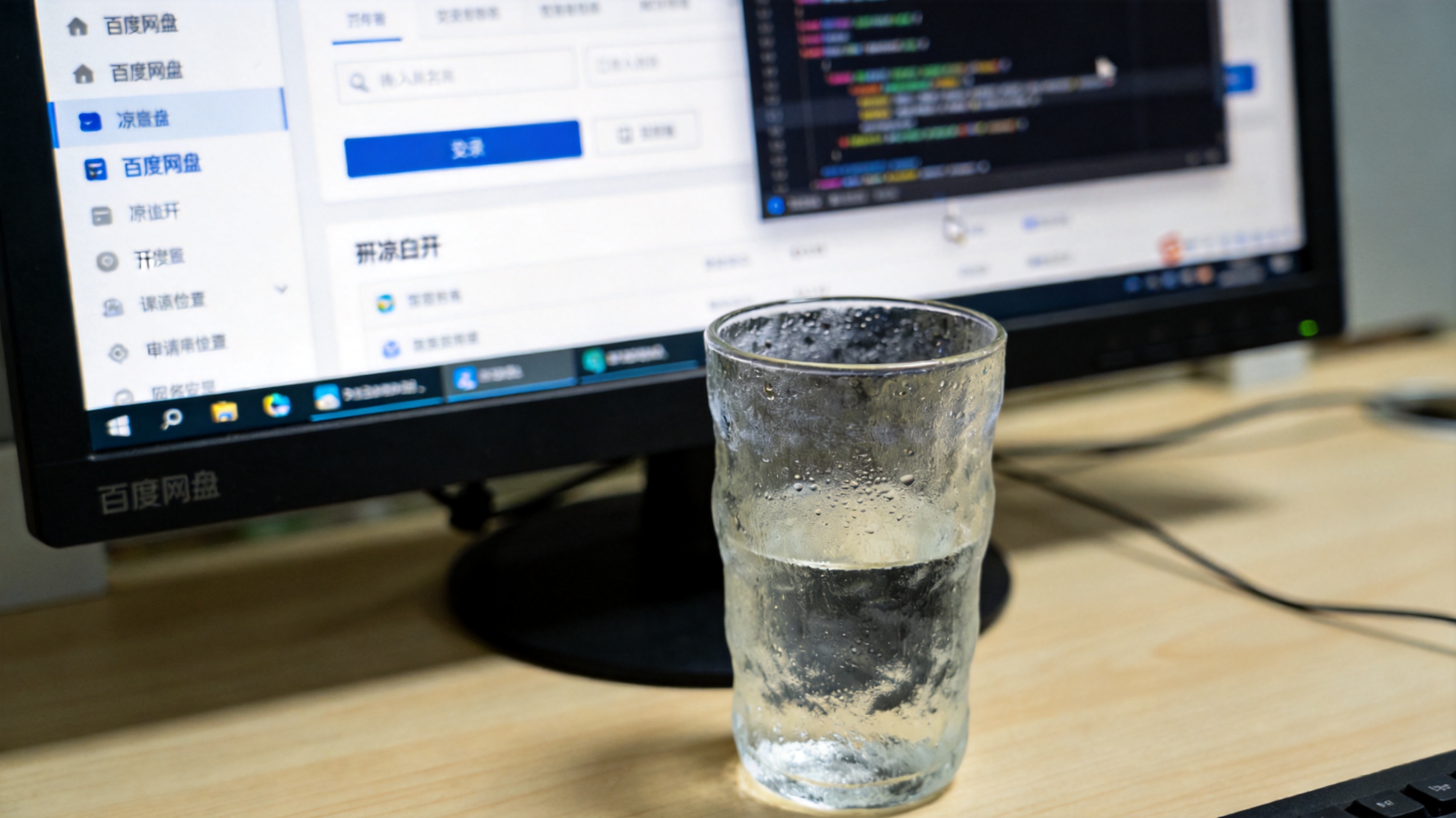 电脑桌面，屏幕显示百度网盘网页版界面，右侧悬浮开发者工具窗口，旁边放着半杯凉白开，室内自然光