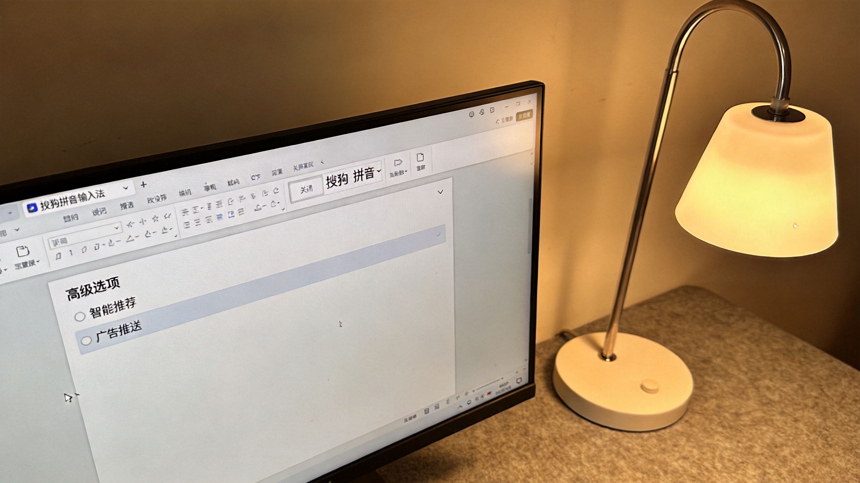 电脑屏幕显示搜狗拼音输入法的设置界面，高级选项里的智能推荐和广告推送已关闭，桌面角落有个普通台灯，开着暖光