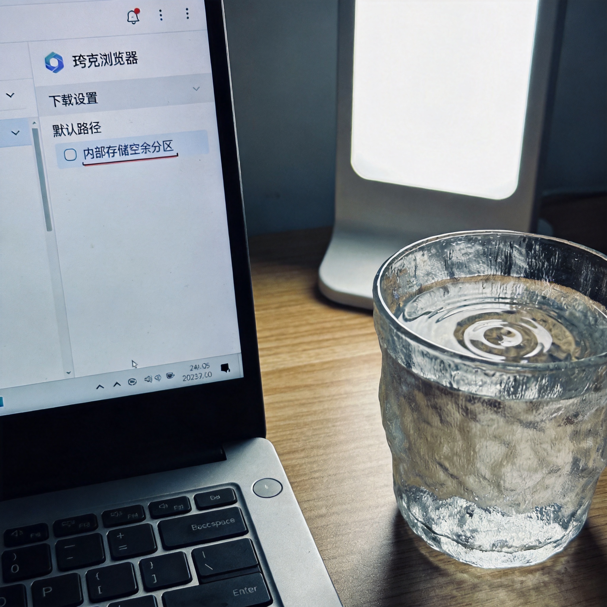 电脑屏幕显示夸克浏览器设置界面，下载设置板块里默认路径选在内部存储空余分区，旁边桌面放着半杯温水，台灯冷光