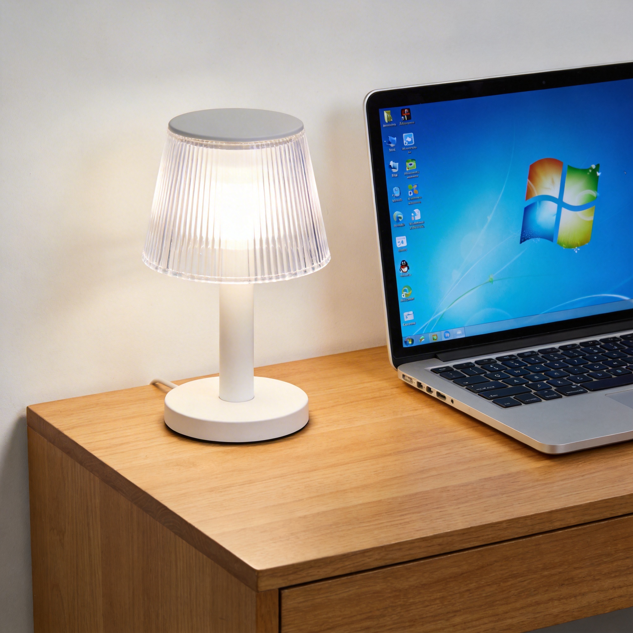 电脑桌上的电脑，屏幕显示Windows界面，旁边放着台灯